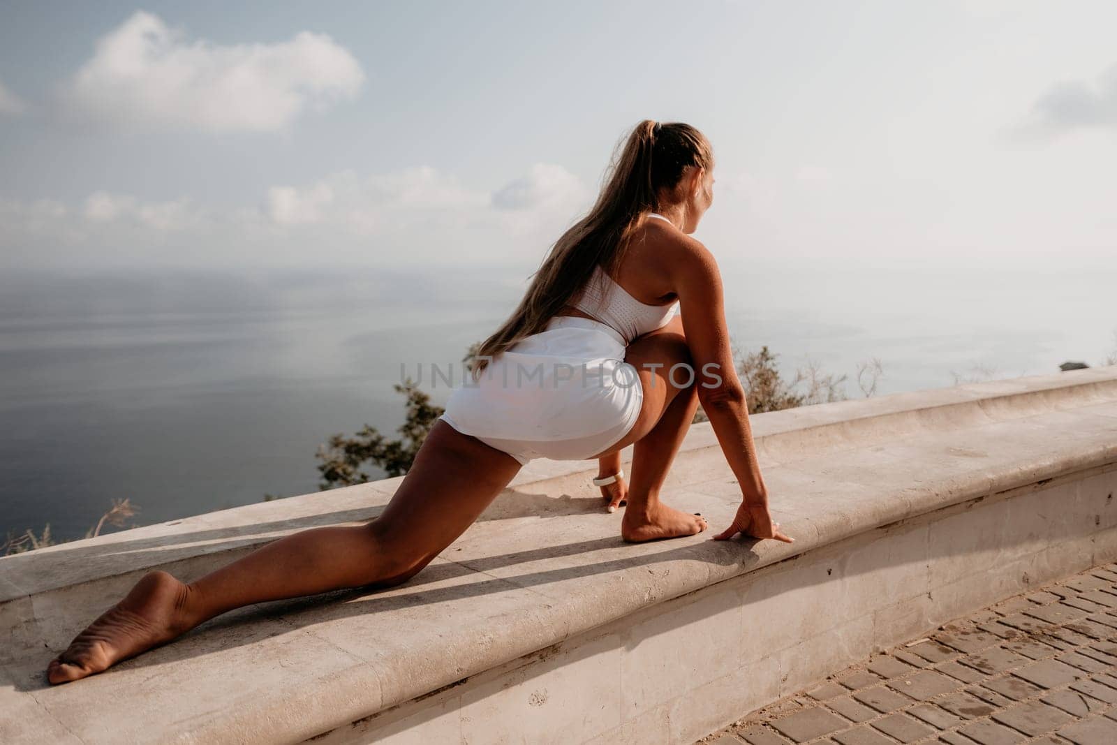 Fitness woman sea. Outdoor workout on yoga mat in park near to ocean beach. Female fitness pilates yoga routine concept. Healthy lifestyle. Happy fit woman exercising with rubber band in park.