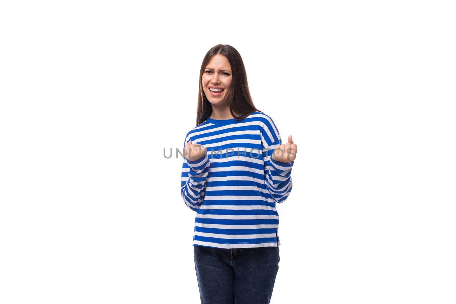 young confident european brunette woman dressed in striped blue clothes on a white studio background.