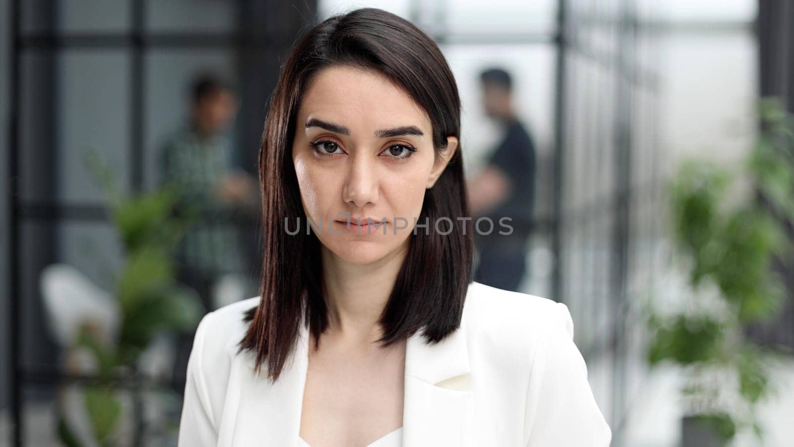 Beautiful young lady in a white jacket with a serious expression looking at the camera