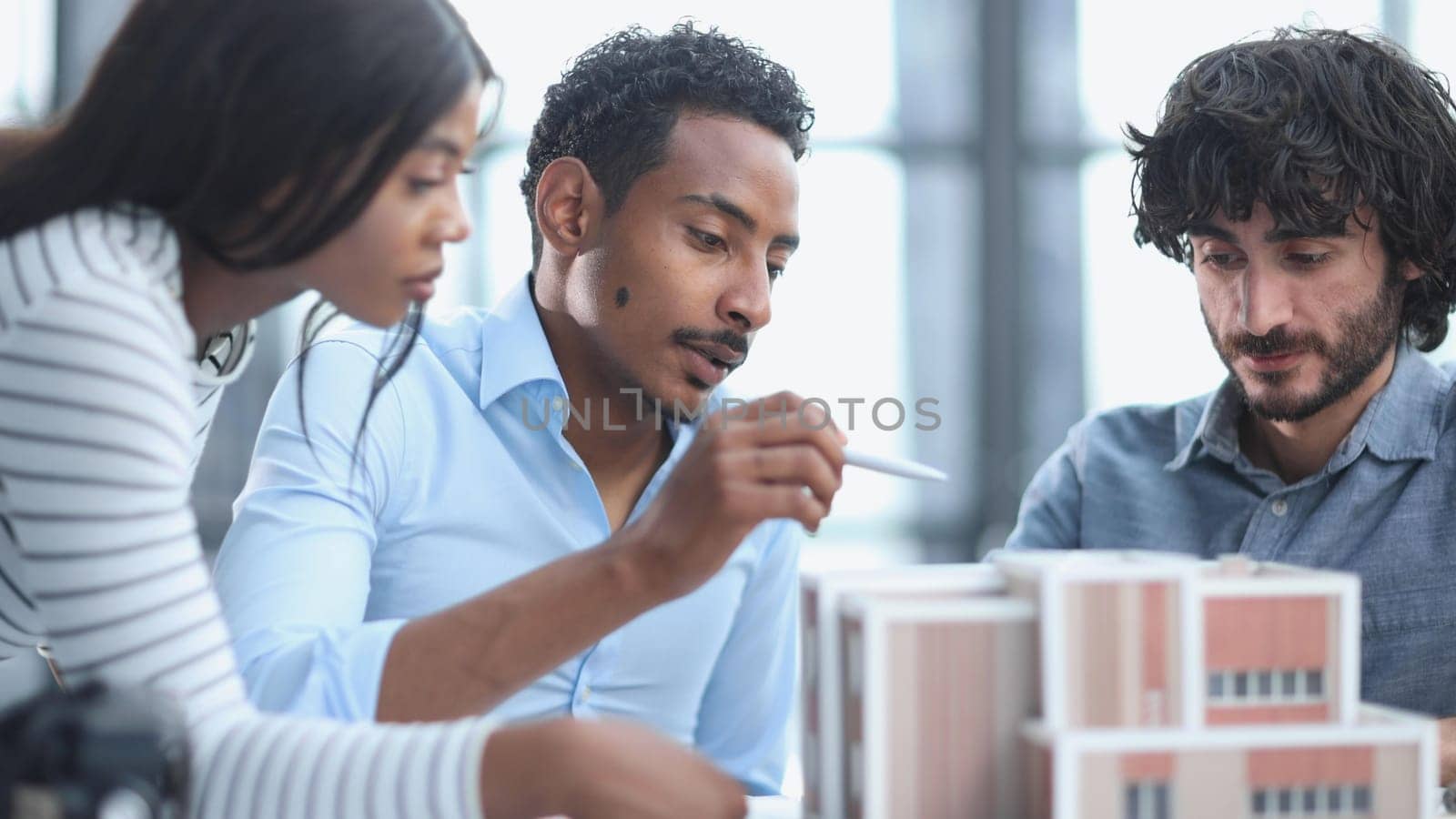 Diverse Group of Employees Smiling and Sitting Together at Conference Table by Prosto