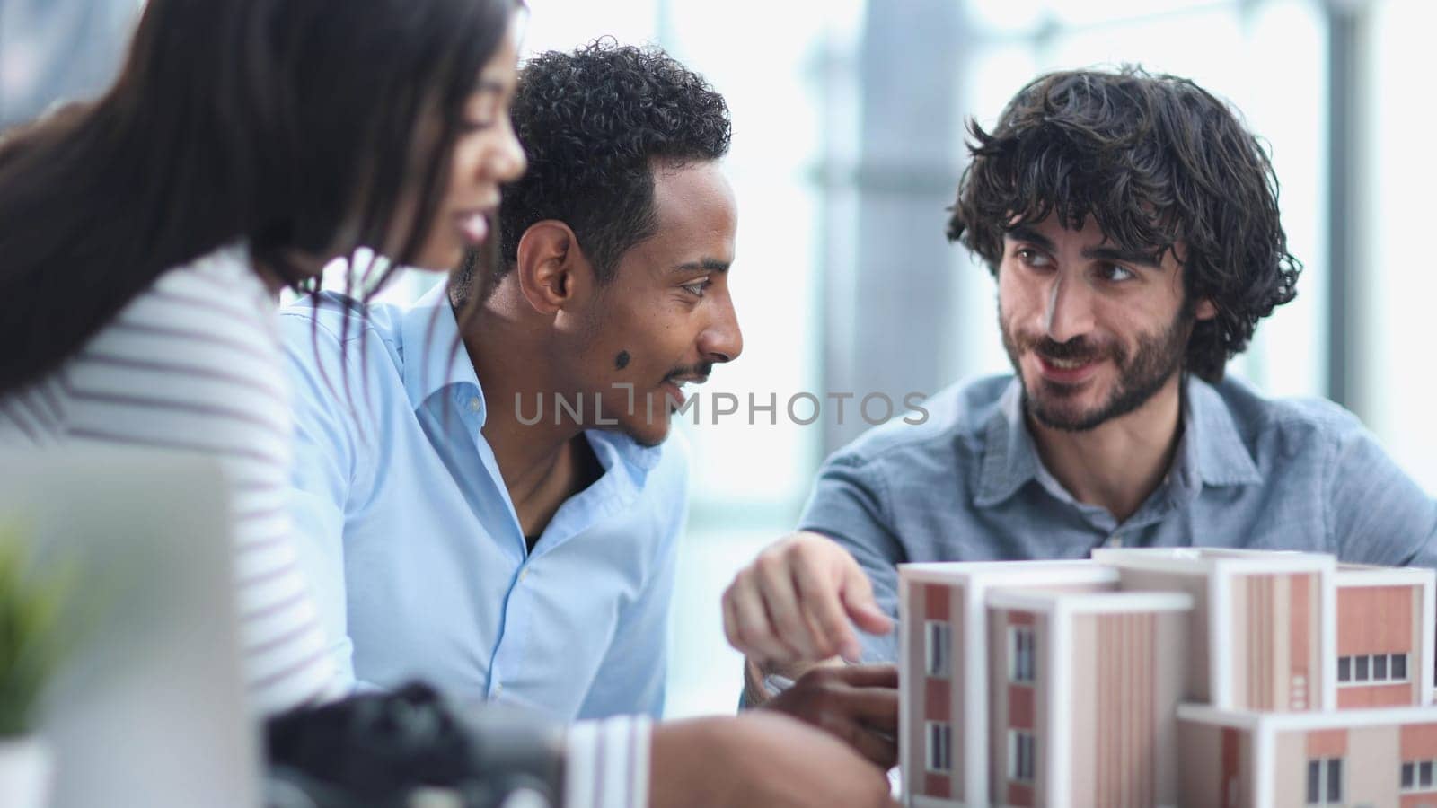 Diverse Group of Employees Smiling and Sitting Together at Conference Table by Prosto