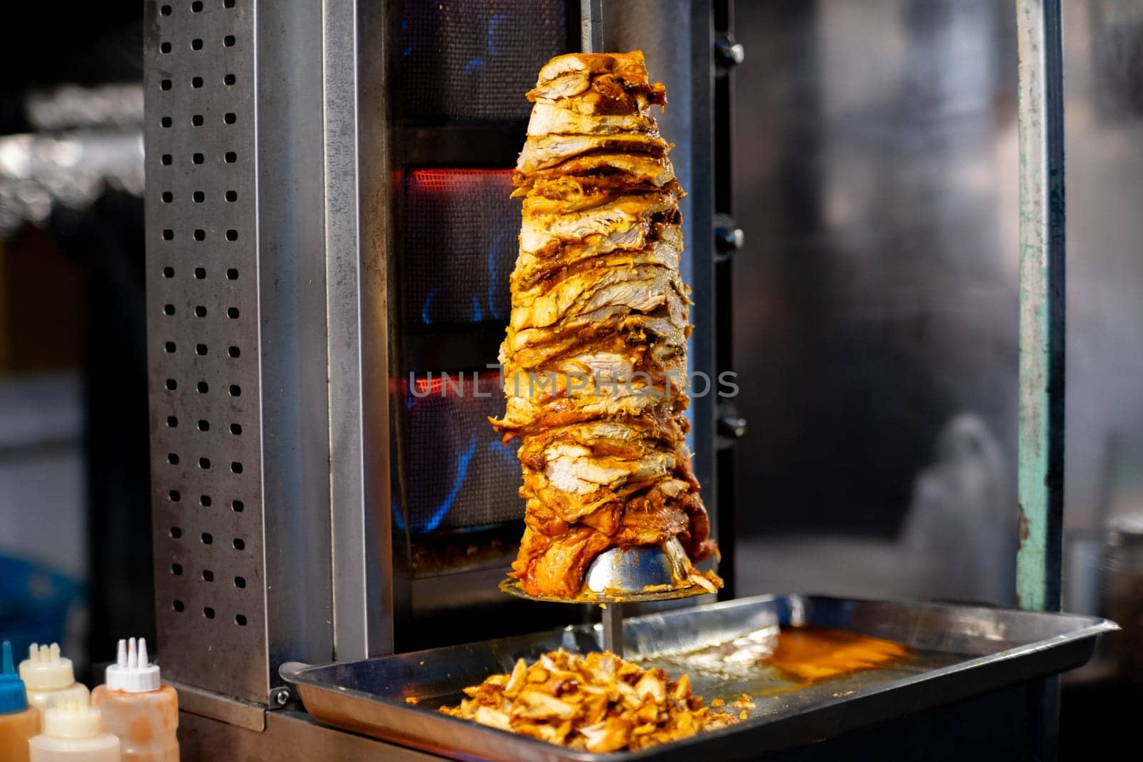 Arab Shawarma of meat chicken preparation placed on spit grilled with burn in the Pai walking street market, Mae Hong Son, Thailand.