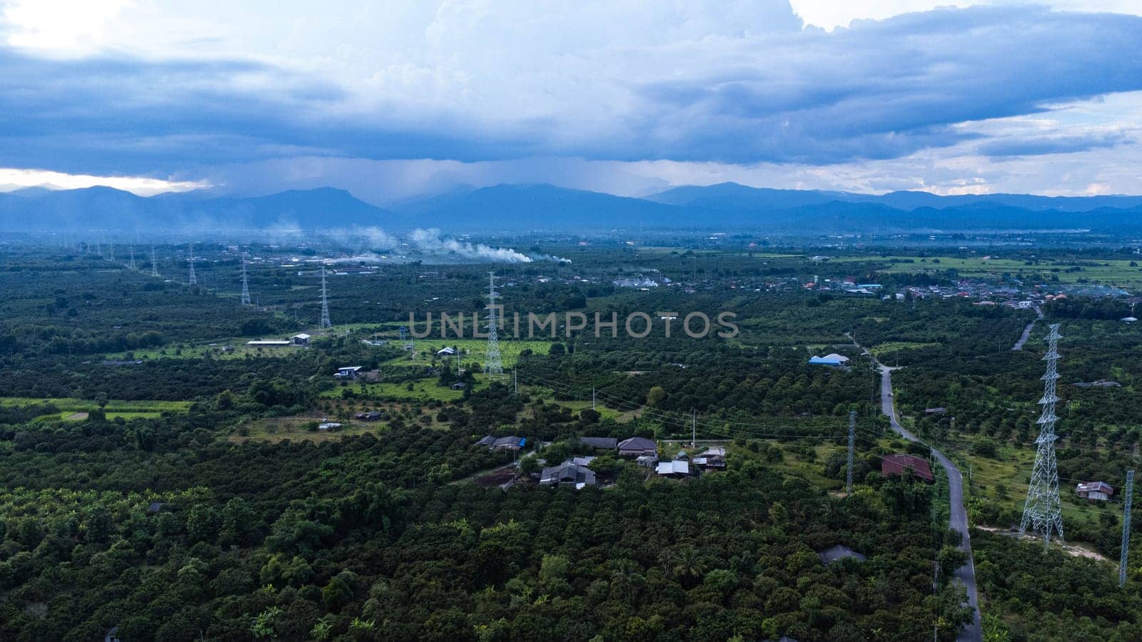 High voltage electric pylon for distributing electricity from power stations to customers through the national electricity grid. High voltage grid tower with wire cable at tree forest. Power and energy concept. Landscape. by TEERASAK