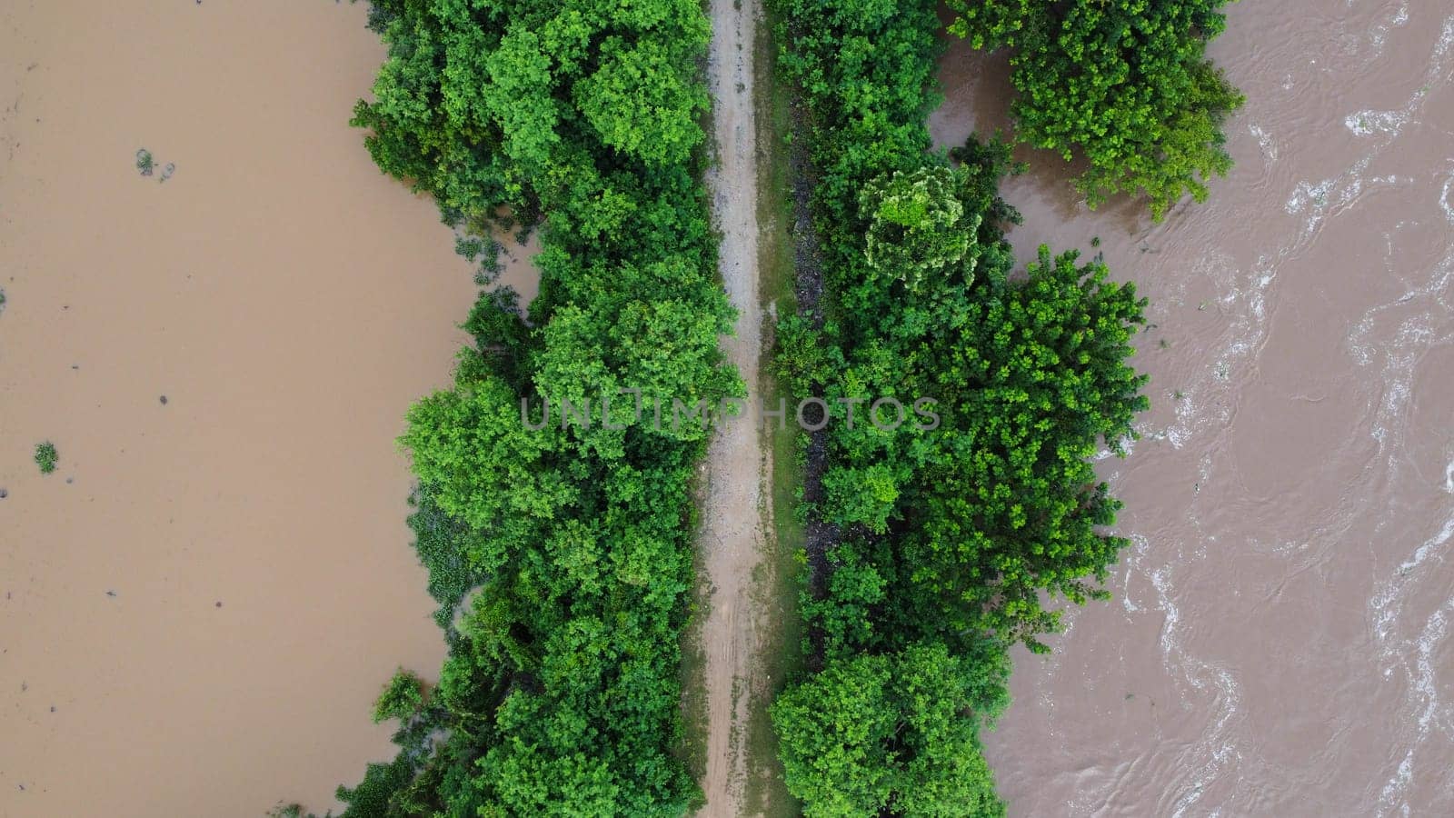 Aerial view of the area affected by rainy season flooding. Top view of a flowing river after heavy rain and flooding of agricultural land in rural northern Thailand. by TEERASAK