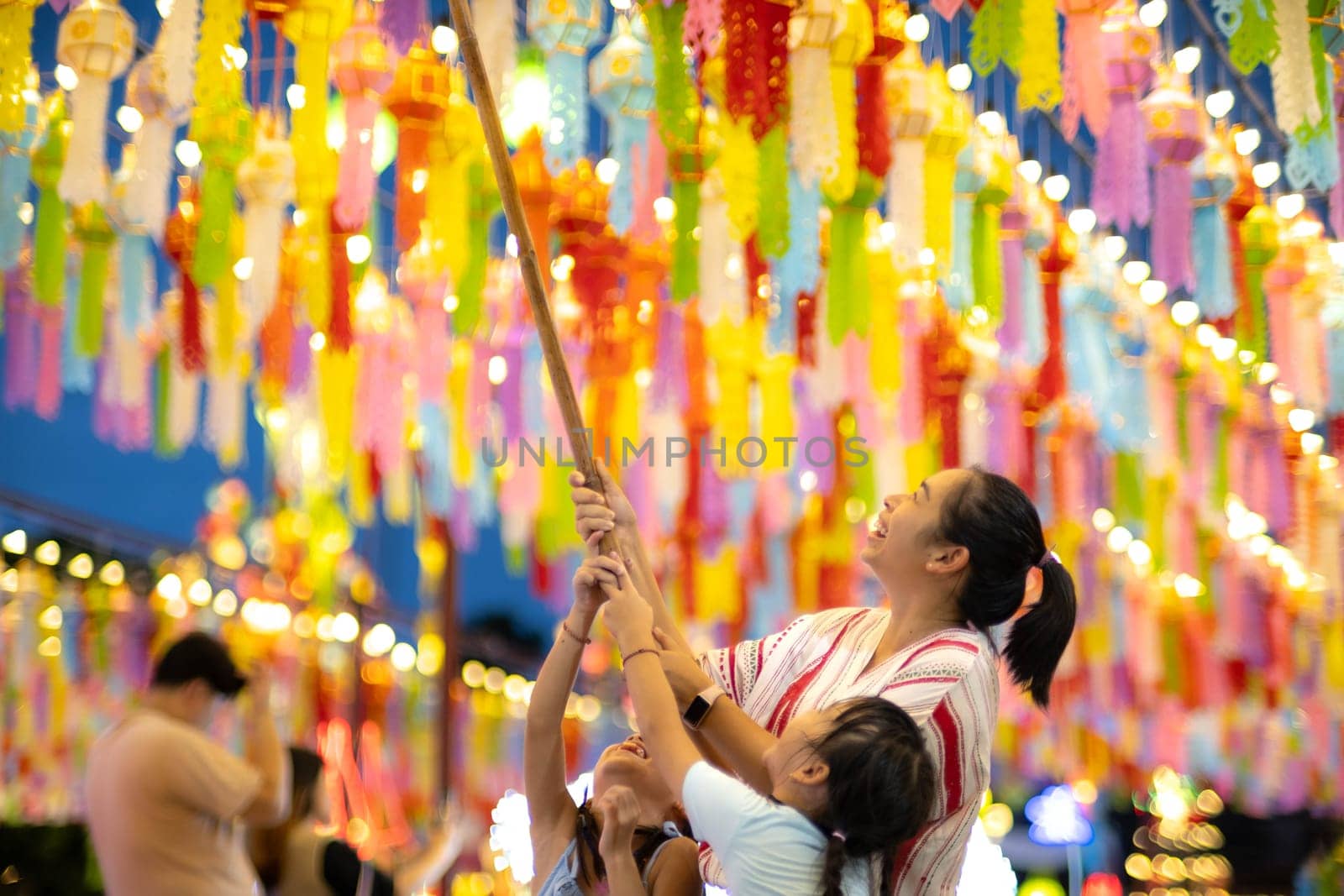 Asian families make wishes and hang lanterns during The Hundred Thousand Lantern Festival or Yi Peng Festival in northern Thailand.