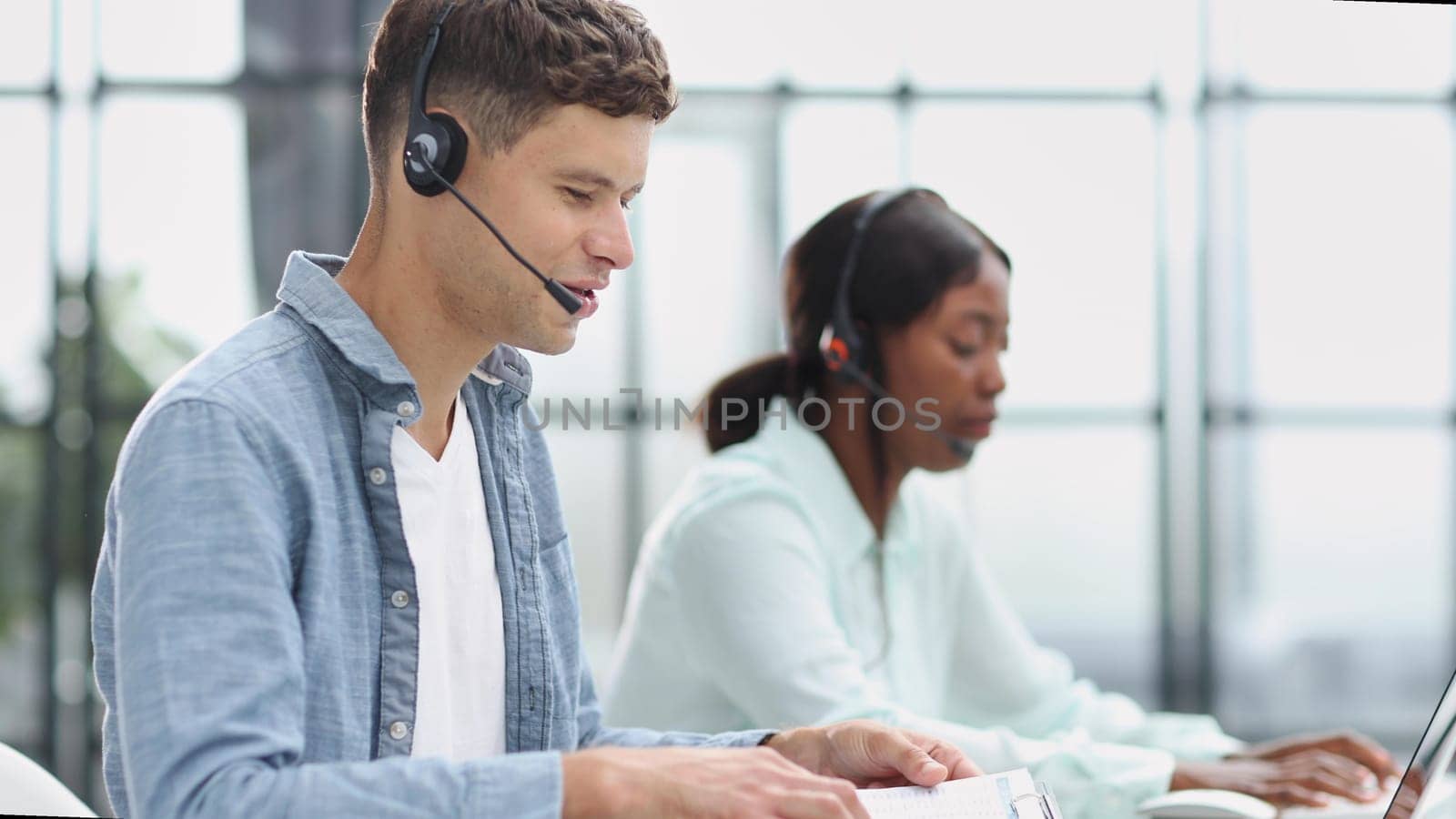 operators woman and man agent with headsets working in a call center by Prosto