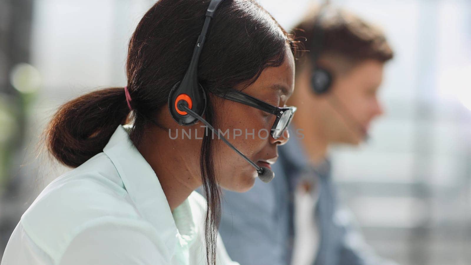 operators woman and man agent with headsets working in a call center by Prosto