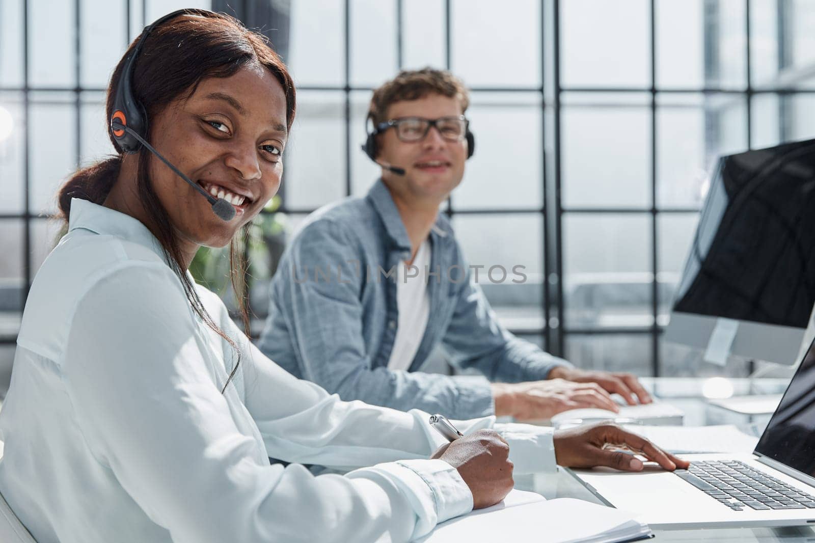 friendly operator woman agent with headsets working in a call center