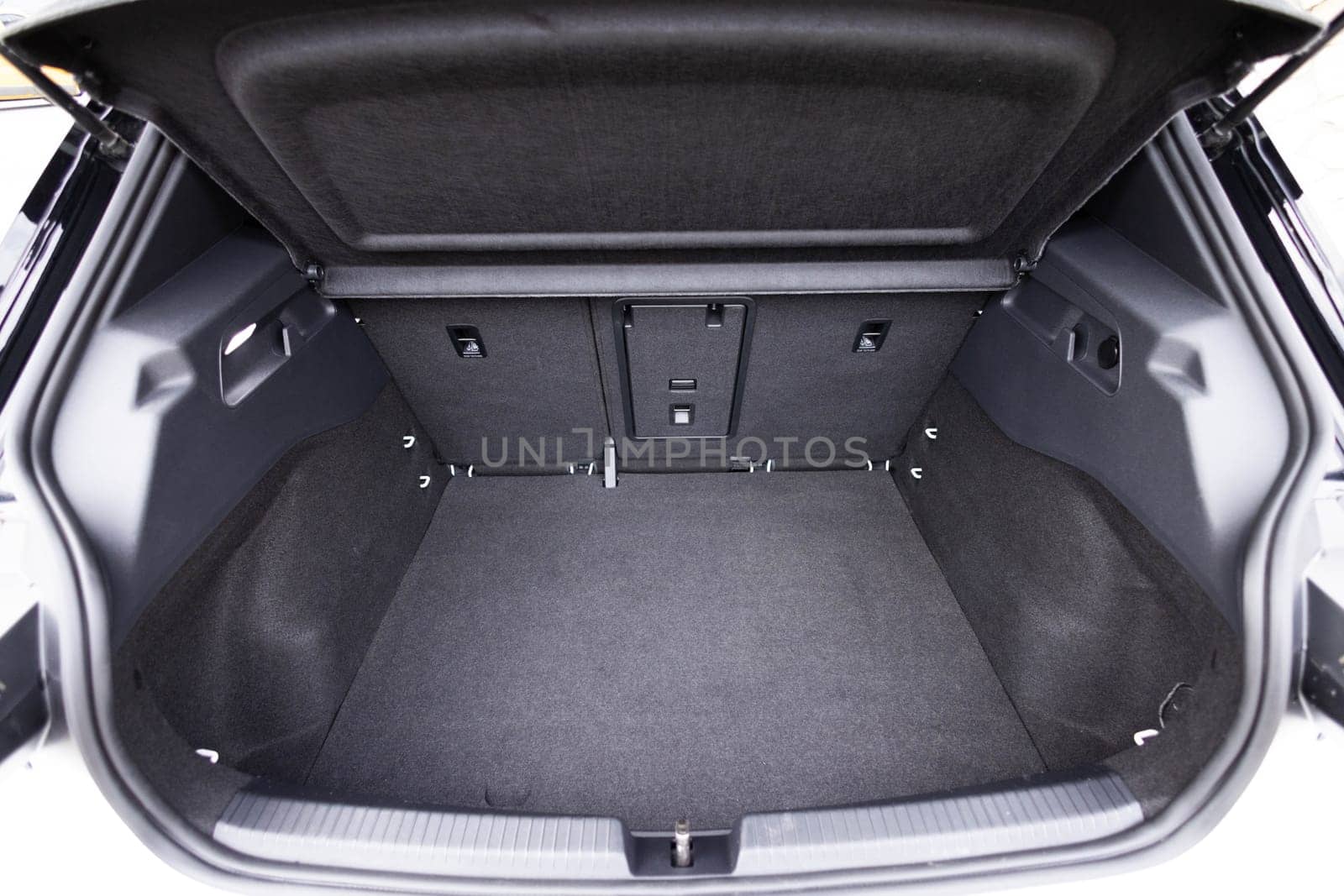 Rear view of the car open trunk. Modern hatchback car with open empty trunk. The car boot is open for luggage. A lot of space for coffers and bags. Ready for a trip. by uflypro