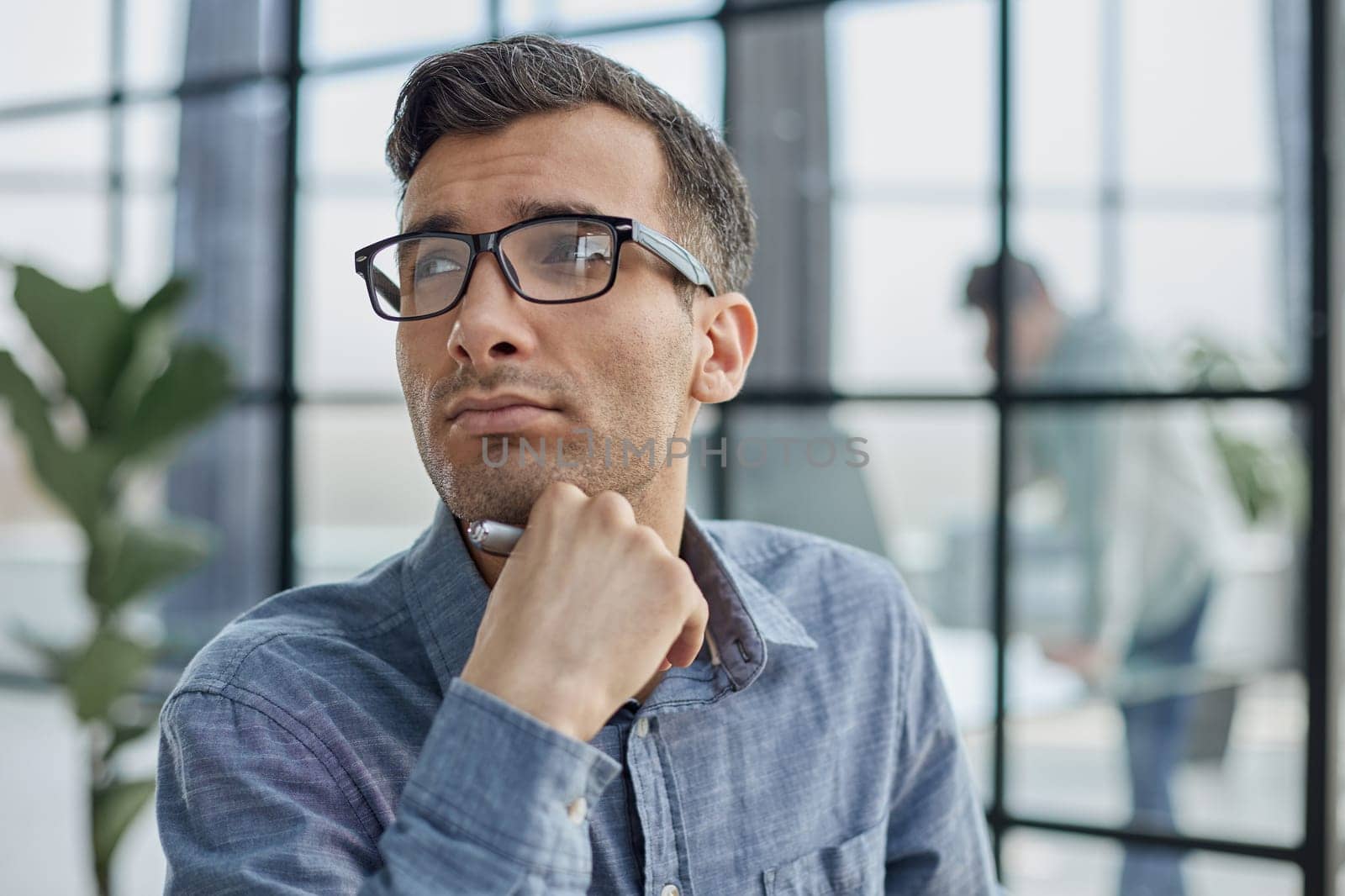 Pensive man in glasses distracted from computer work look in distance thinking or pondering