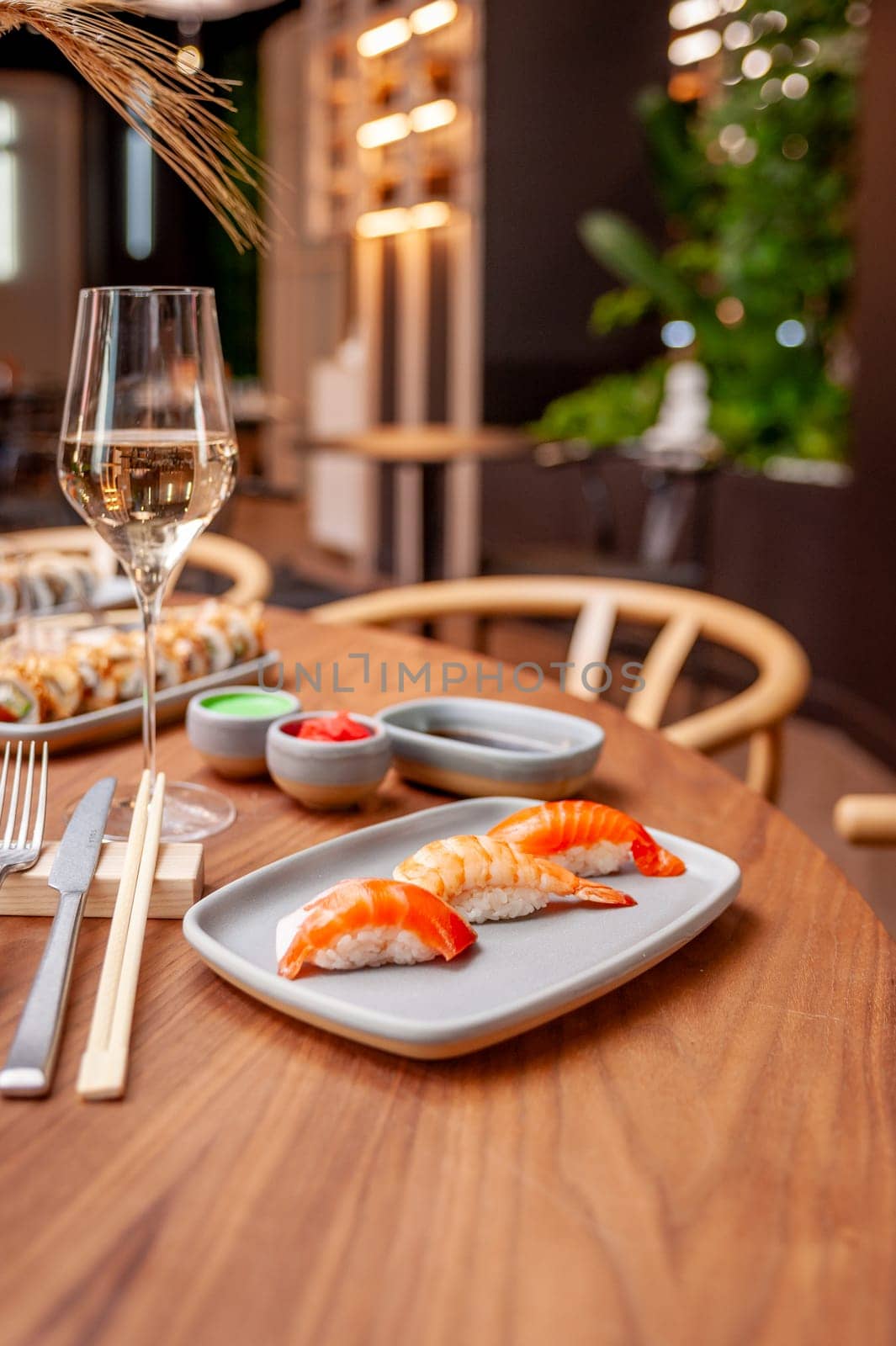 Nigiri set: salmon, shrimp, tuna on a plate on a table in a sushi bar on a plate close-up. High quality photo