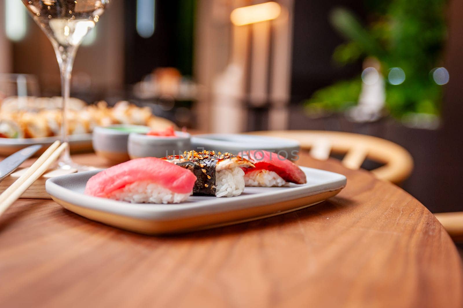 Nigiri set: tuna, eel and tuna tataki on a plate on a table in a sushi bar on a plate close-up. High quality photo