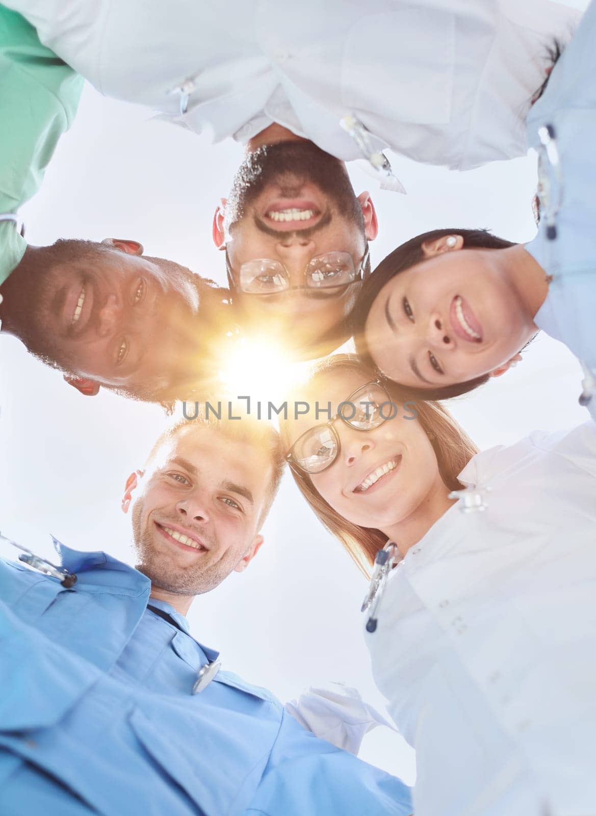 GROUP OF MULTINATIONAL INTERNS LOOKING DOWN Smiling by Prosto