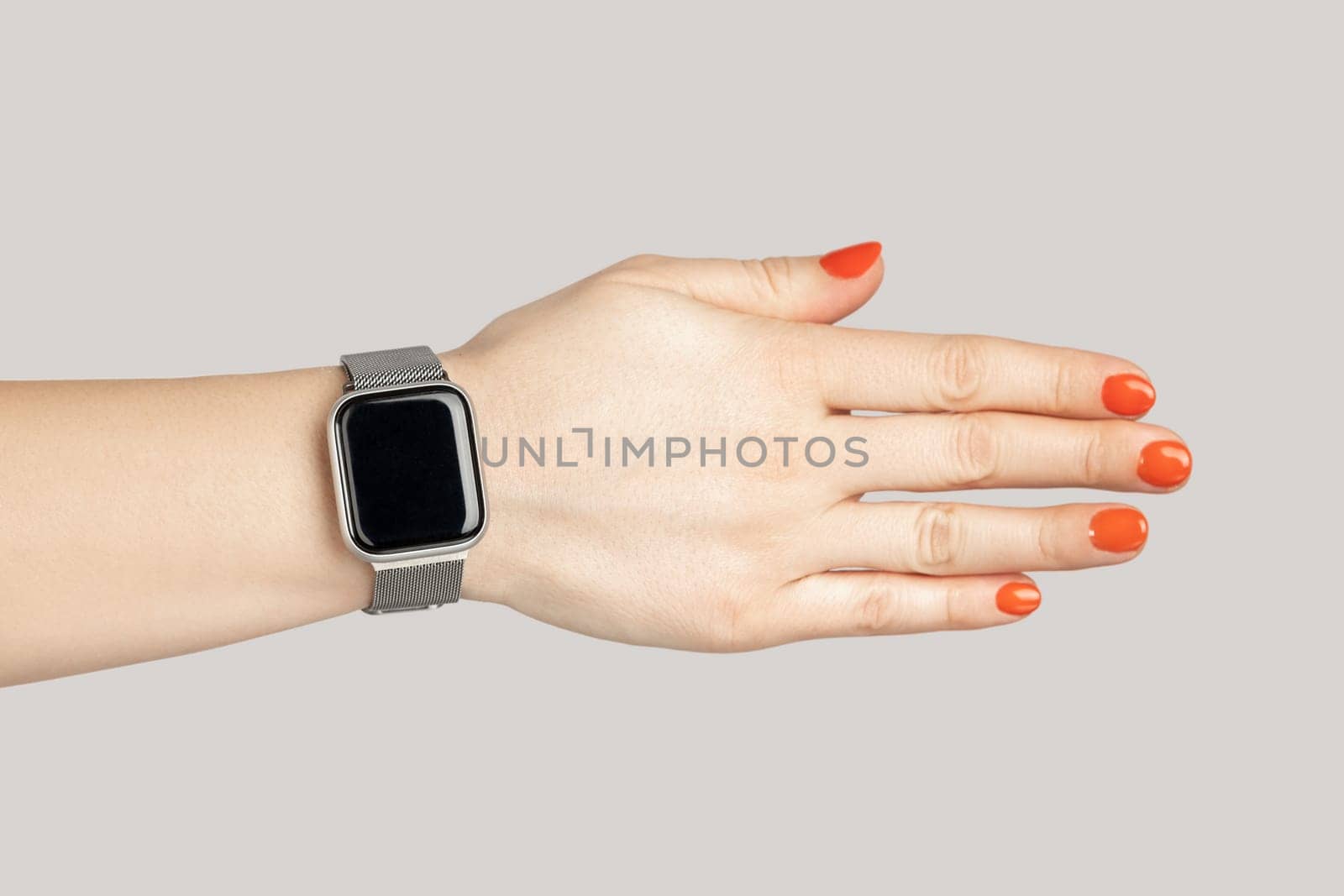 Closeup of woman hand with smartwatch with empty display handshaking with partner. Indoor studio shot isolated on gray background.