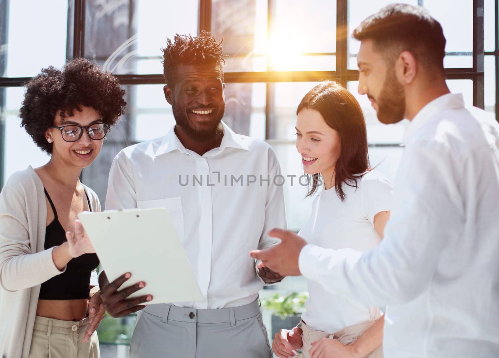 Happy young female employee discussing online project, showing computer presentation to skilled team leader in eyeglasses. Friendly diverse colleagues working in pairs on laptop, using applications.