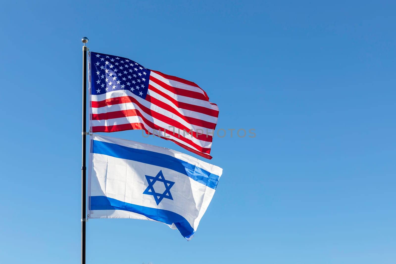 Waving Flags Of USA And Israel On The Same Flagpole On Background Of Blue Sky. Copy Space For Text. Design, Template Horizontal Plane by netatsi