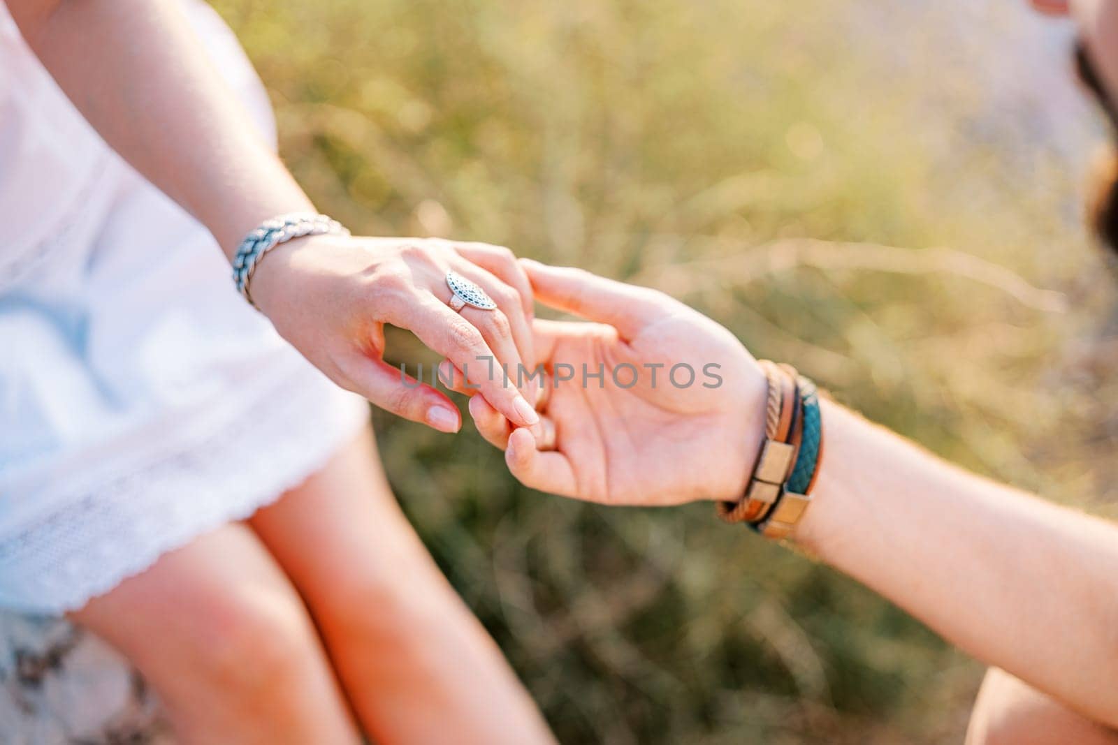 Groom holds bride hand in his own. Cropped. Faceless. High quality photo