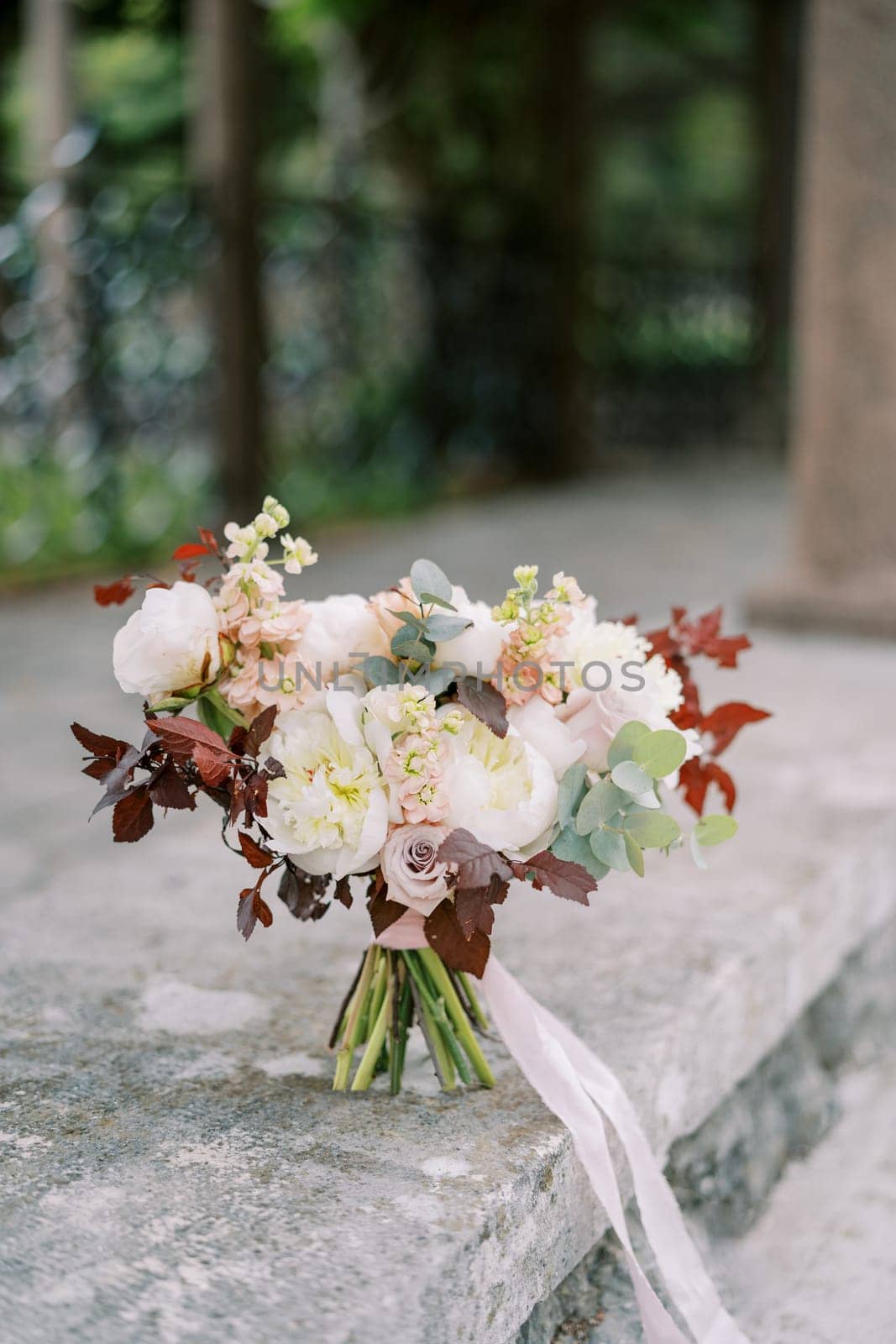 Wedding bouquet stands on a stone slab in the garden. High quality photo