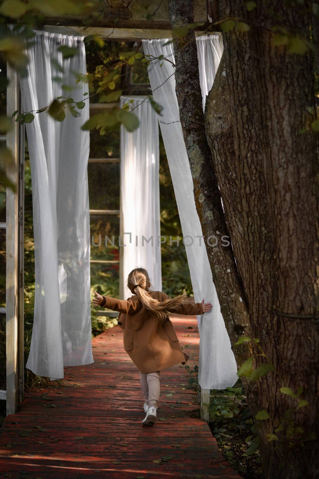 A girl in a mystical forest and flying curtains