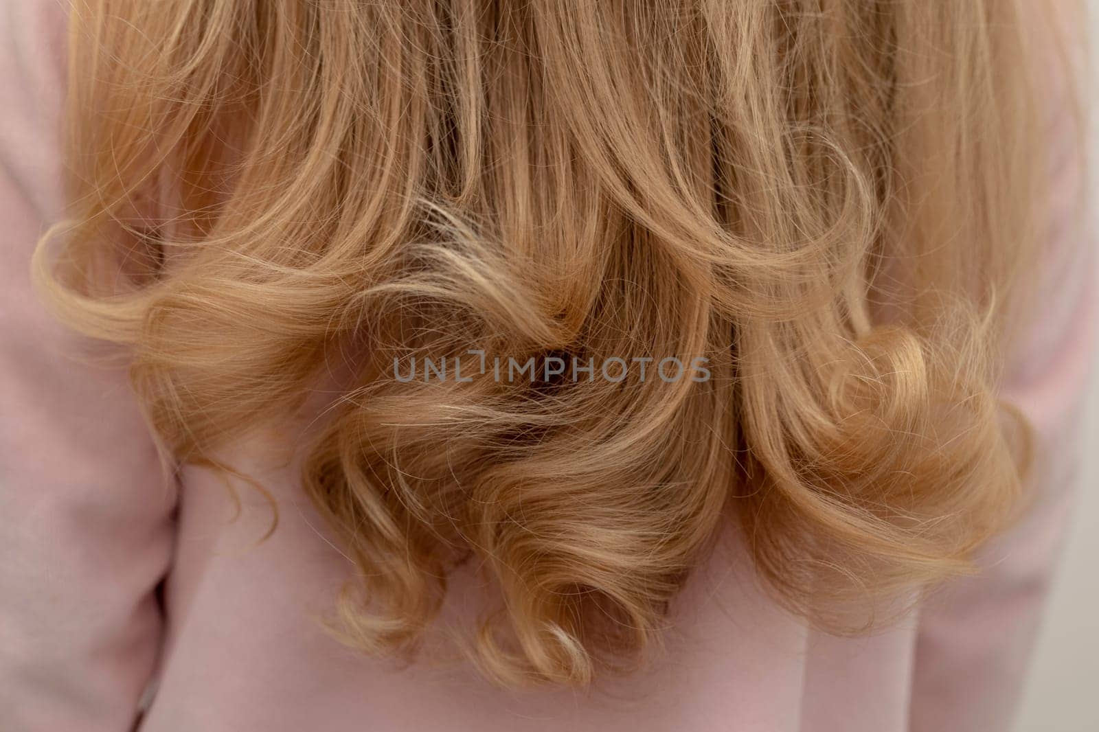 The girl is standing back with beautiful curly hair