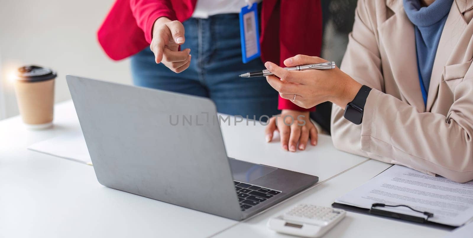 Close-up shot of two businesswoman hands brainstorming to work on a desk. by wichayada