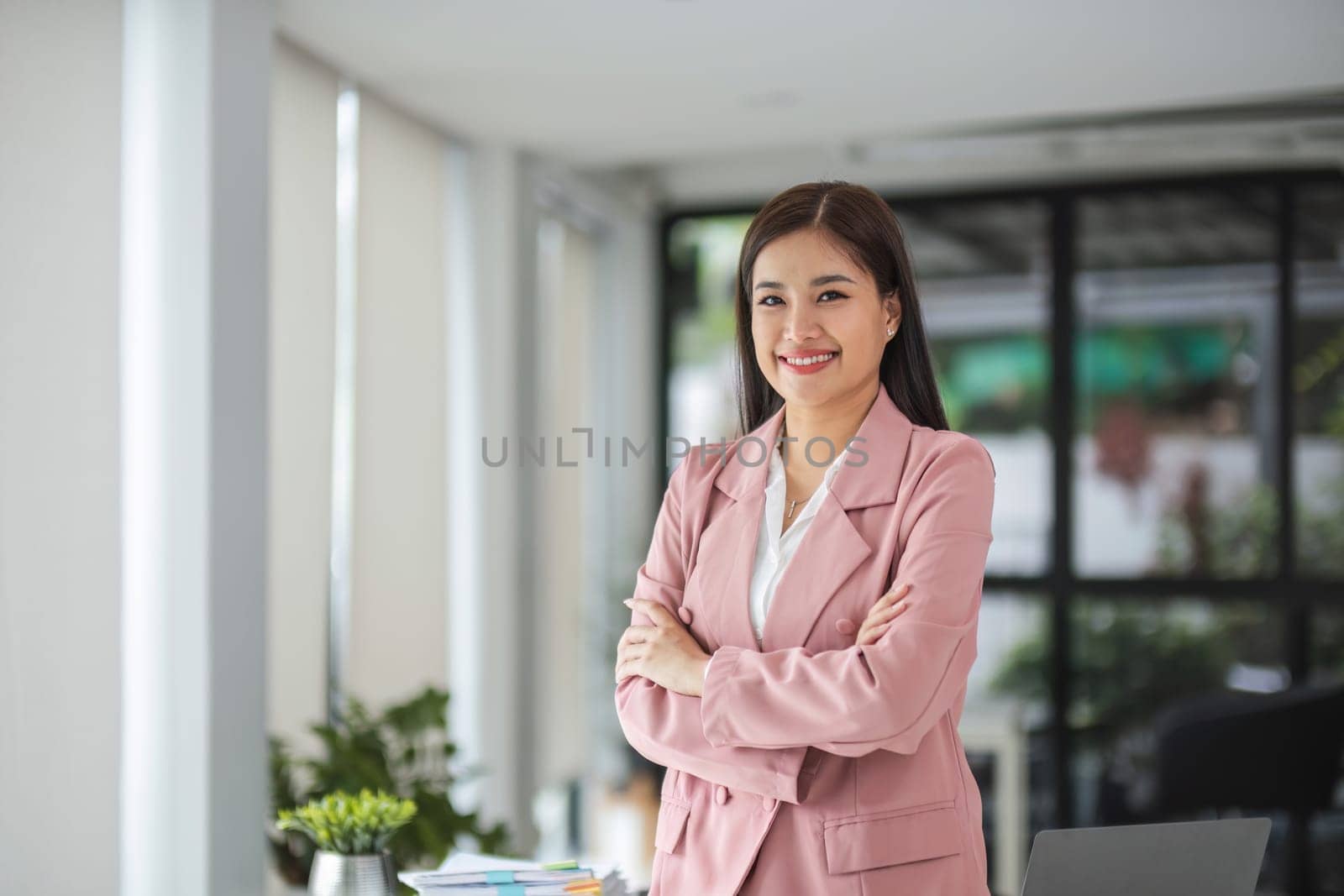 Portrait, Successful businesswoman leader in suit standing in office with arms crossed..