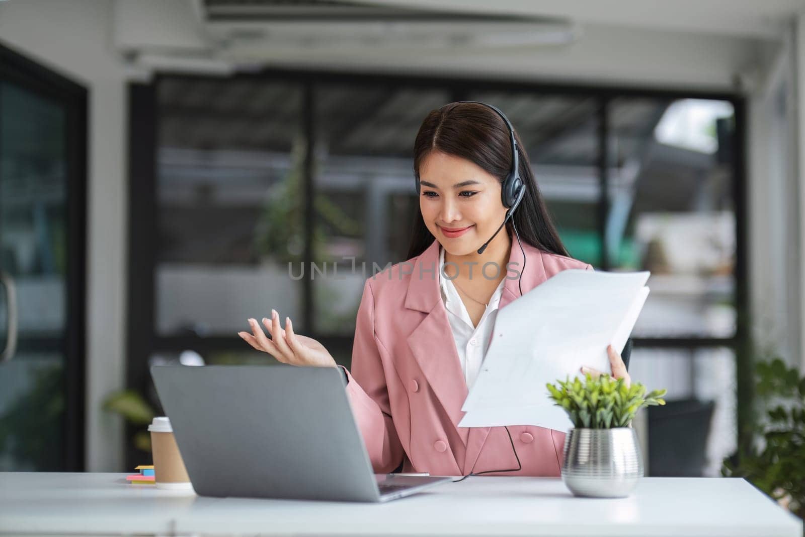 A call center operator is explaining job details to a customer on a laptop..