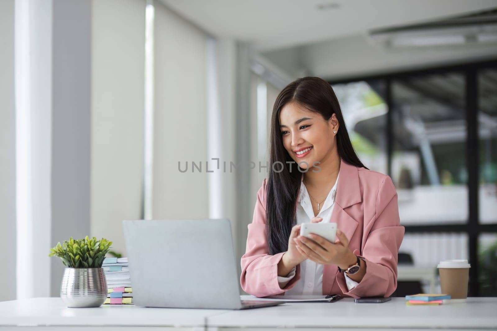 Businesswoman using a calculator to calculate financial expenses at the office for financial analysis. by wichayada