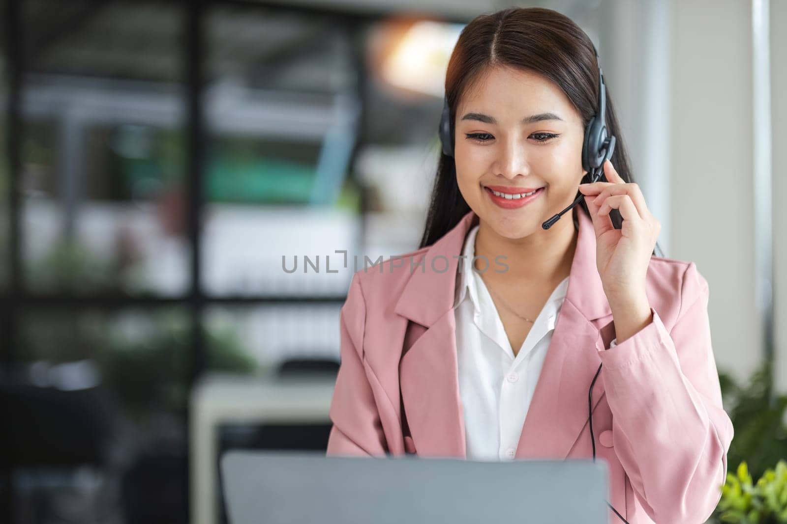 A call center operator is explaining job details to a customer on a laptop..