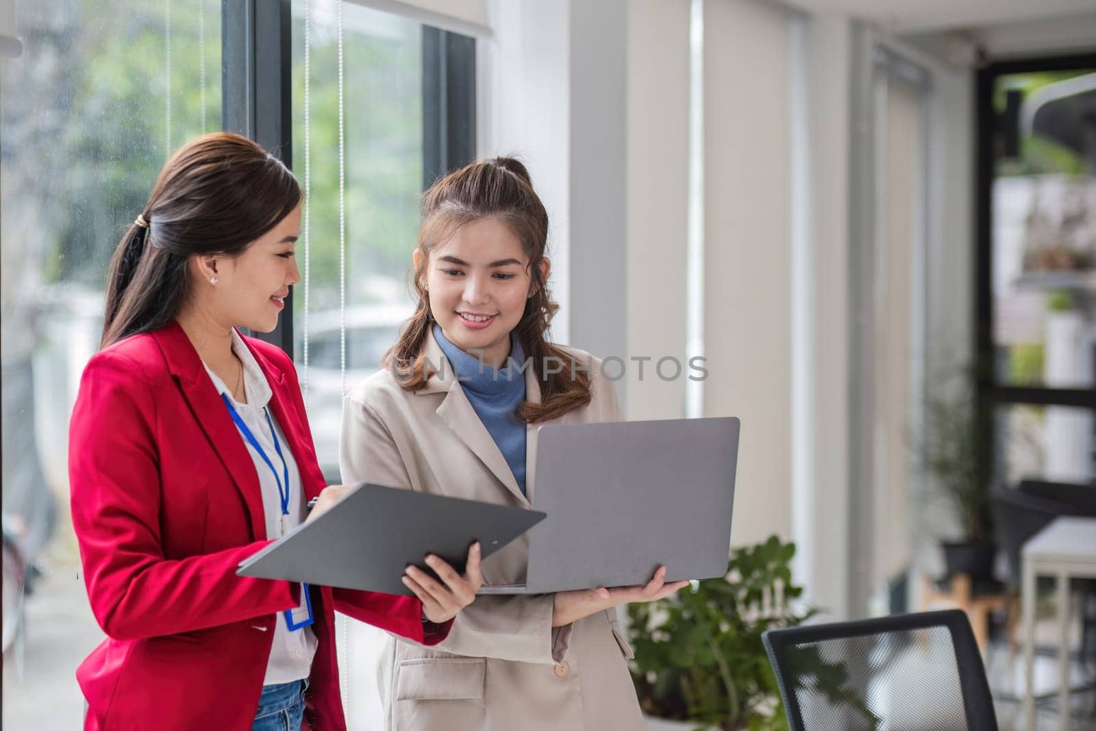 Two business women are discussing and exchanging knowledge on graphs and finance data..