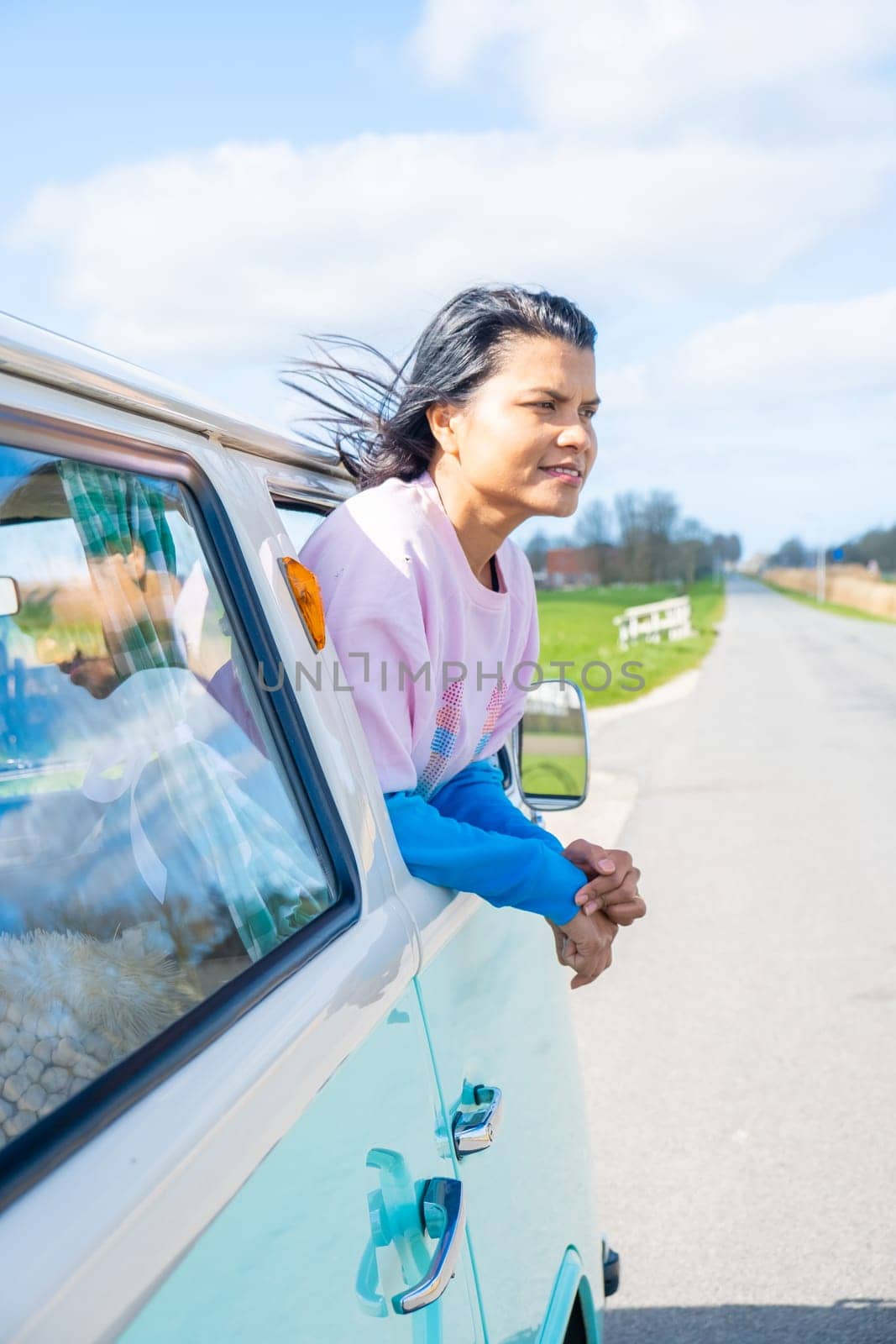 couple doing a road trip with an old vintage car in the Dutch flower bulb region with tulip fields by fokkebok