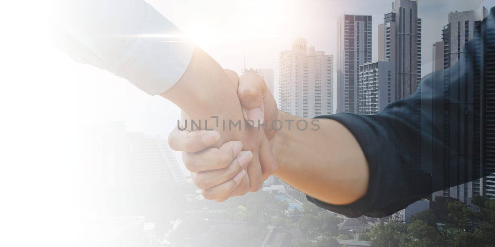 Close up of businessman handshake on abstract city background. Teamwork concept. Double exposure.