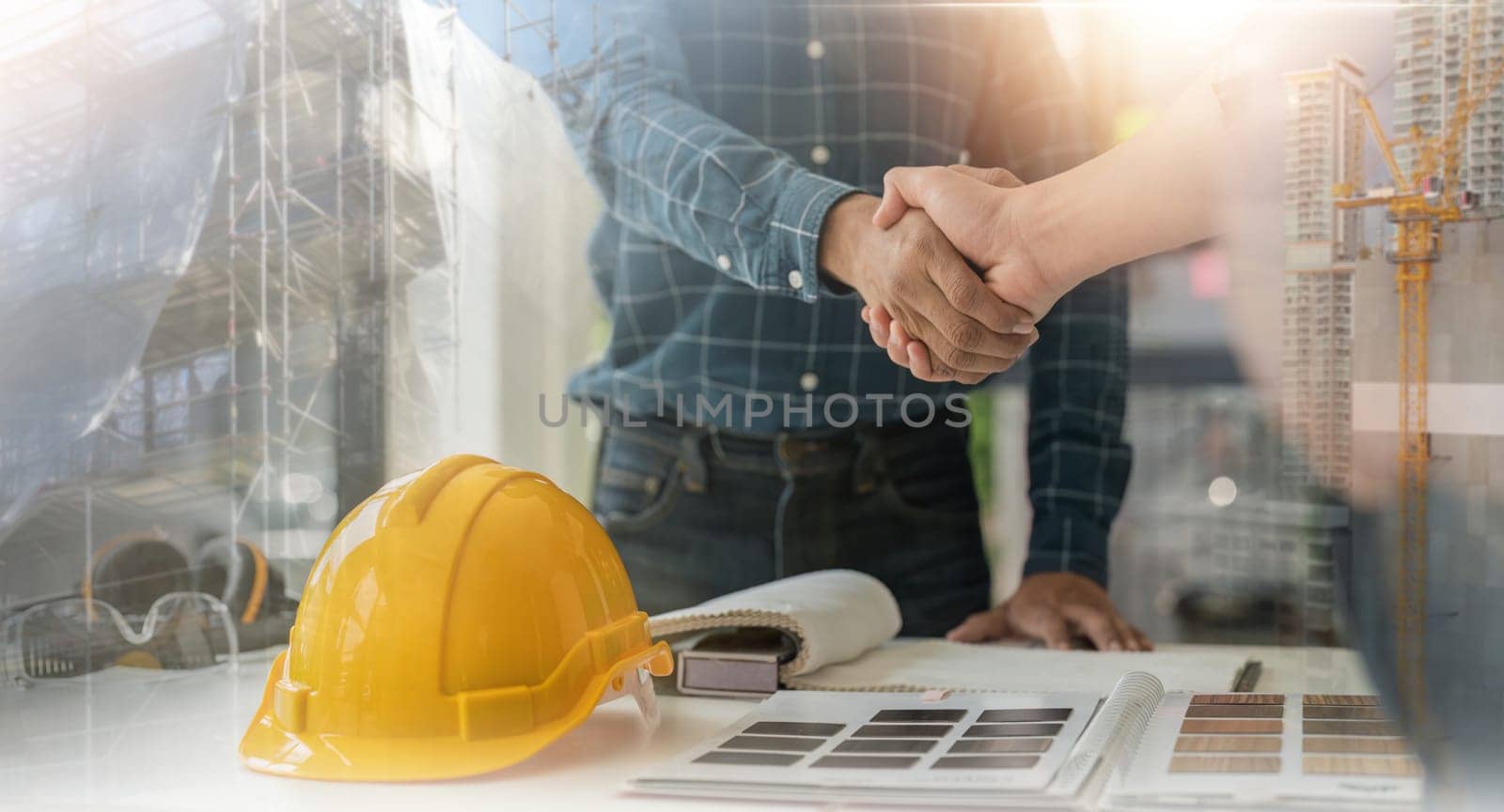 Engineer team hardhat yellow standing handshake. construction engineer working together on a building project.