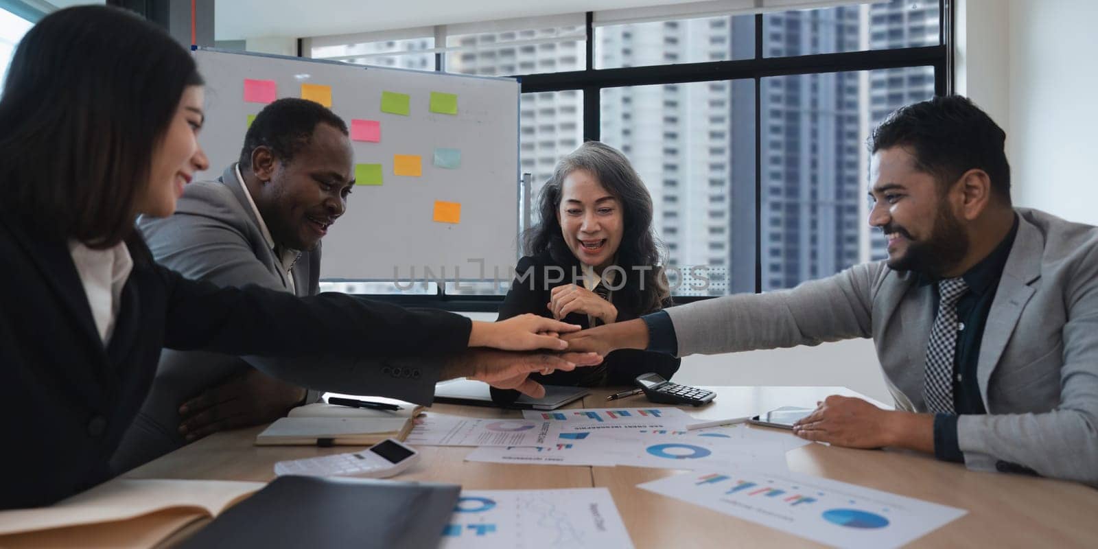 Business people diversity ethnicity stack touch arms palms together celebrating promotion reward, succeed common aim. Give high five symbol of unity.