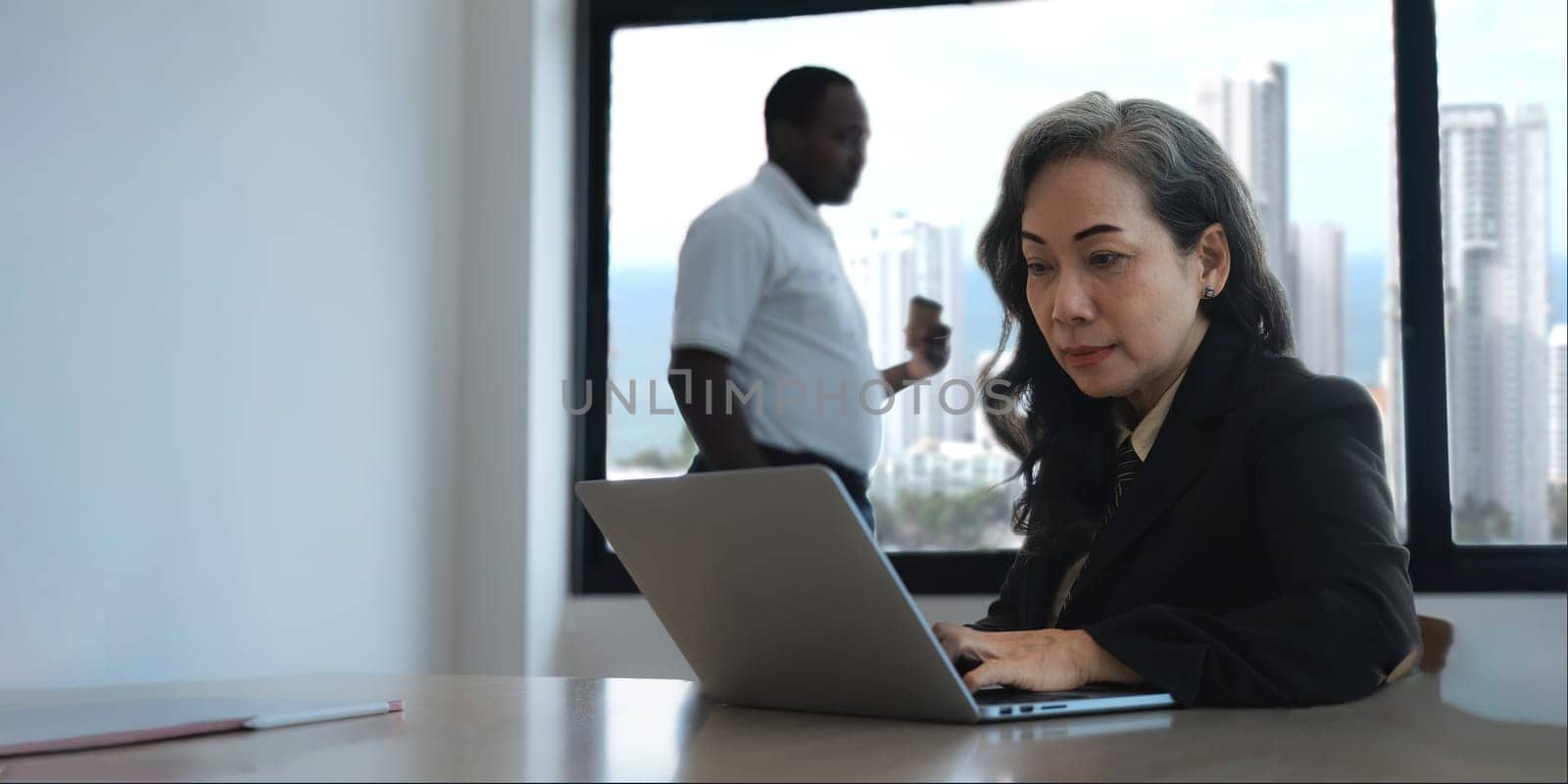 Senior asian business woman a confidence using laptop in the office with a diversity ethnicity background.