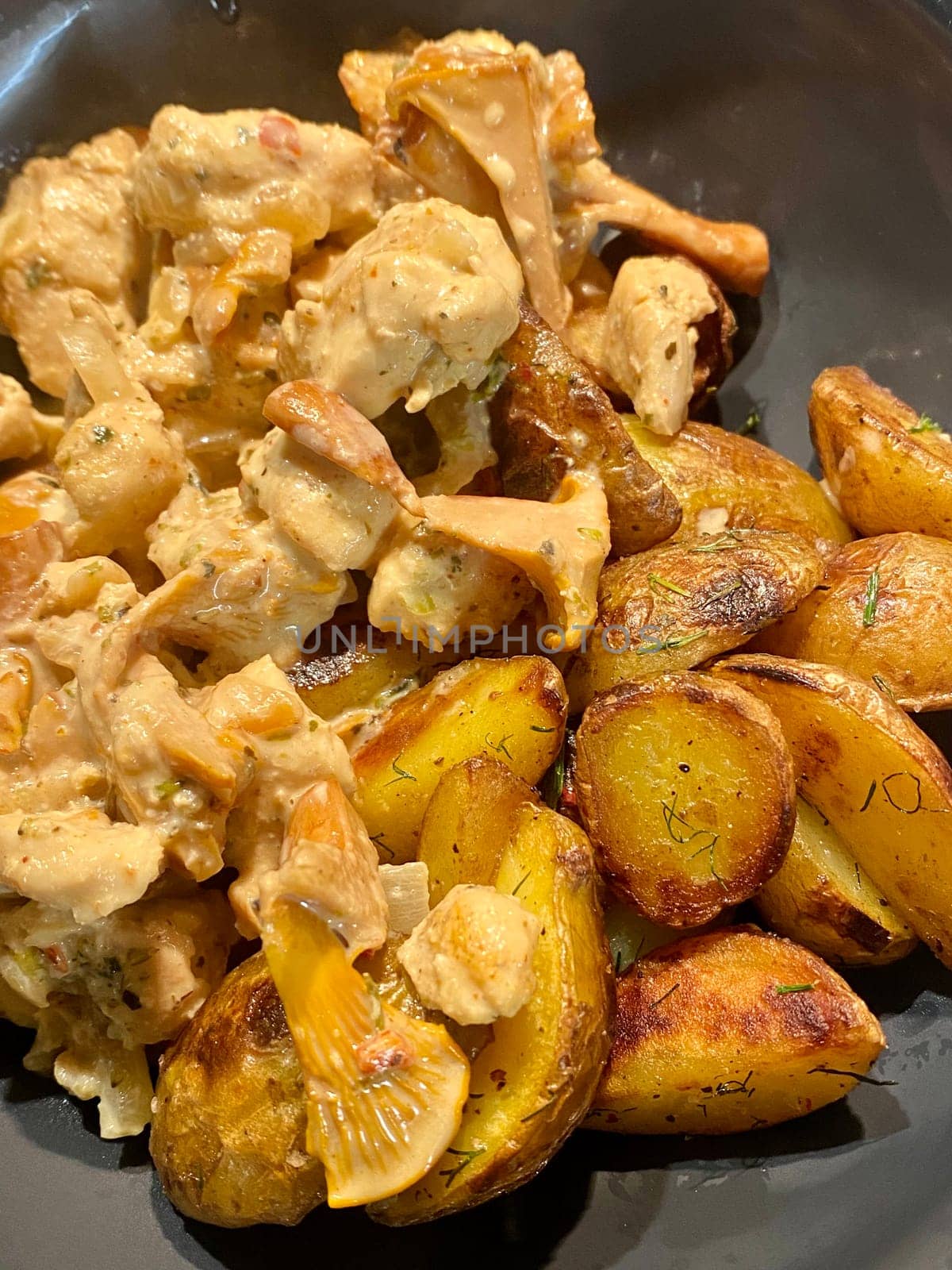 Close up view baked potato with meat and fox mushrooms in creamy sauce, homemade food by DailySF