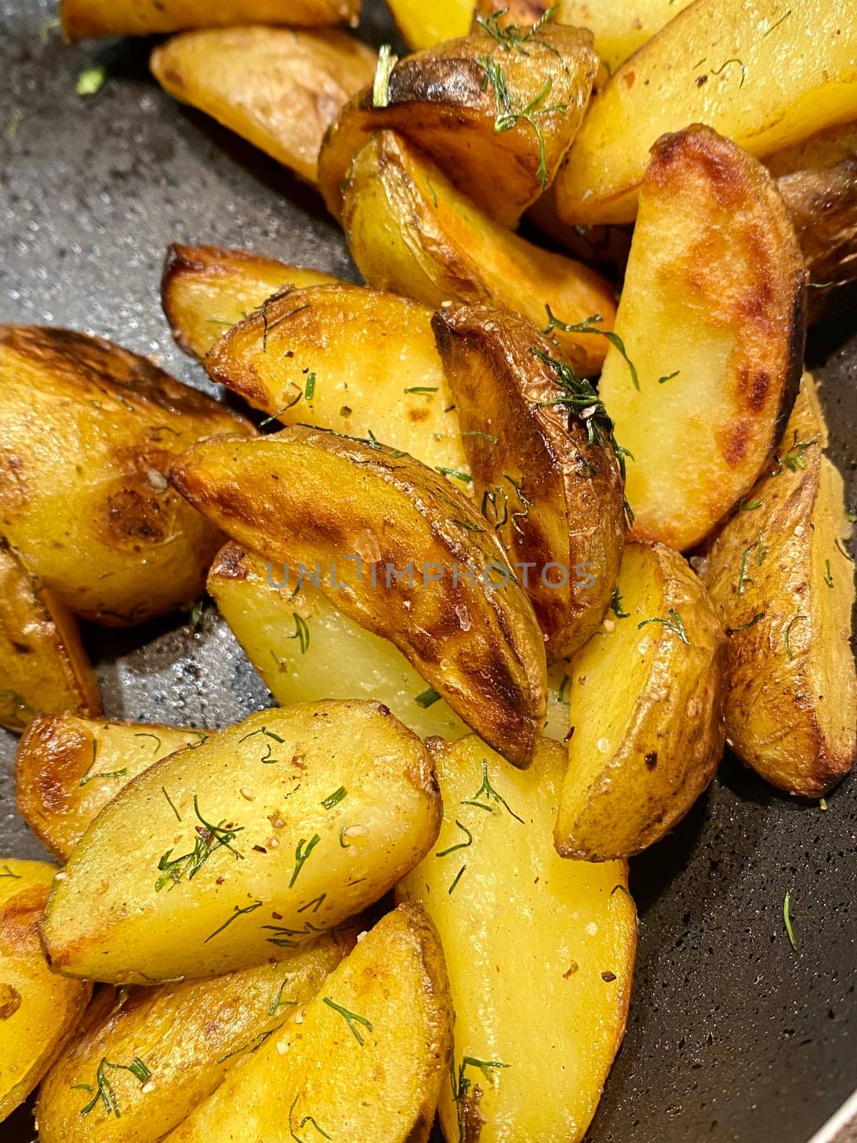 Potato wedged, oven roasted with dill, a close up in a baking tray by DailySF