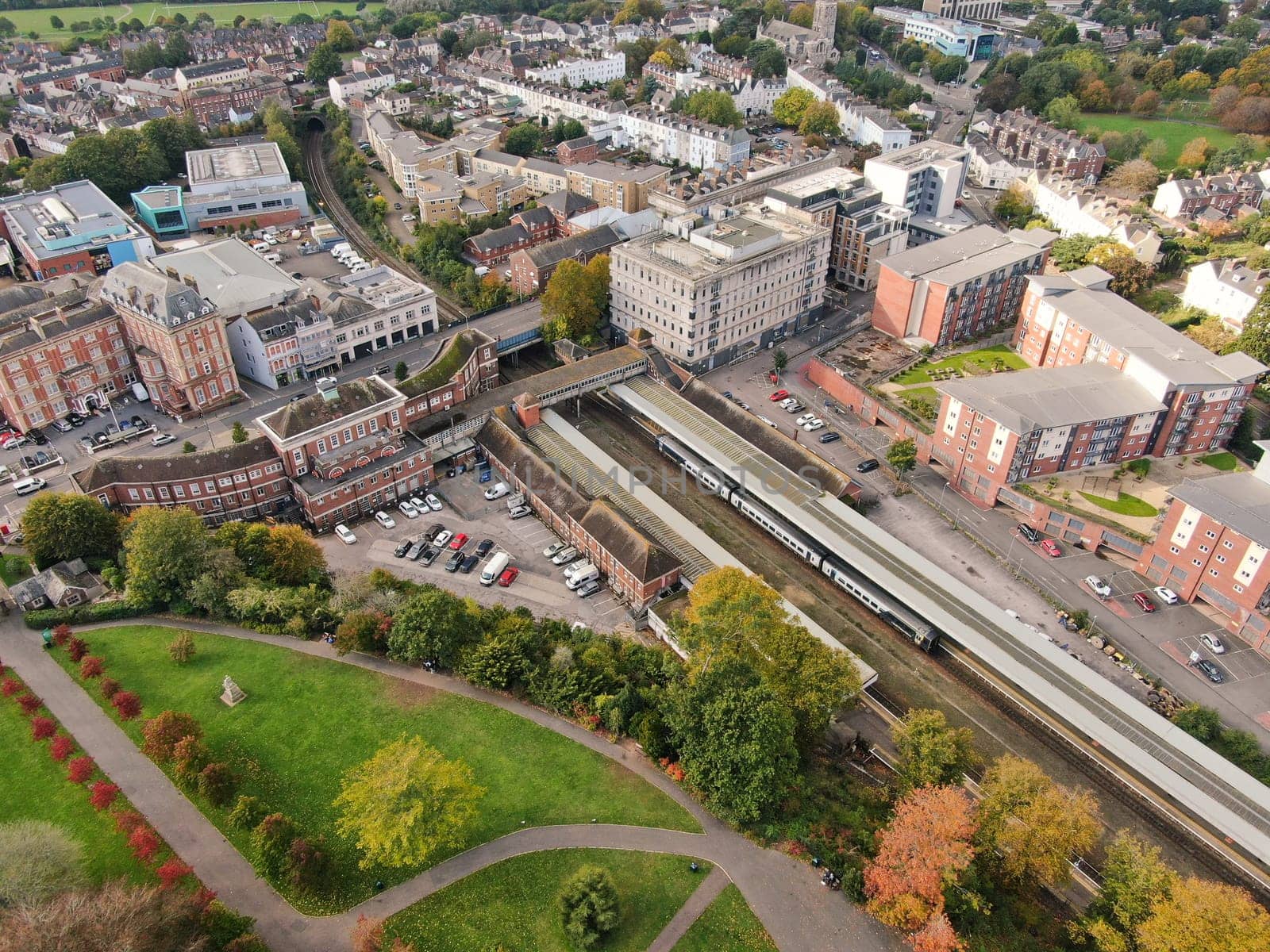 a drone eye view flying above Exeter in Devon , UK looking towards the railway station with a train visible in the platform
