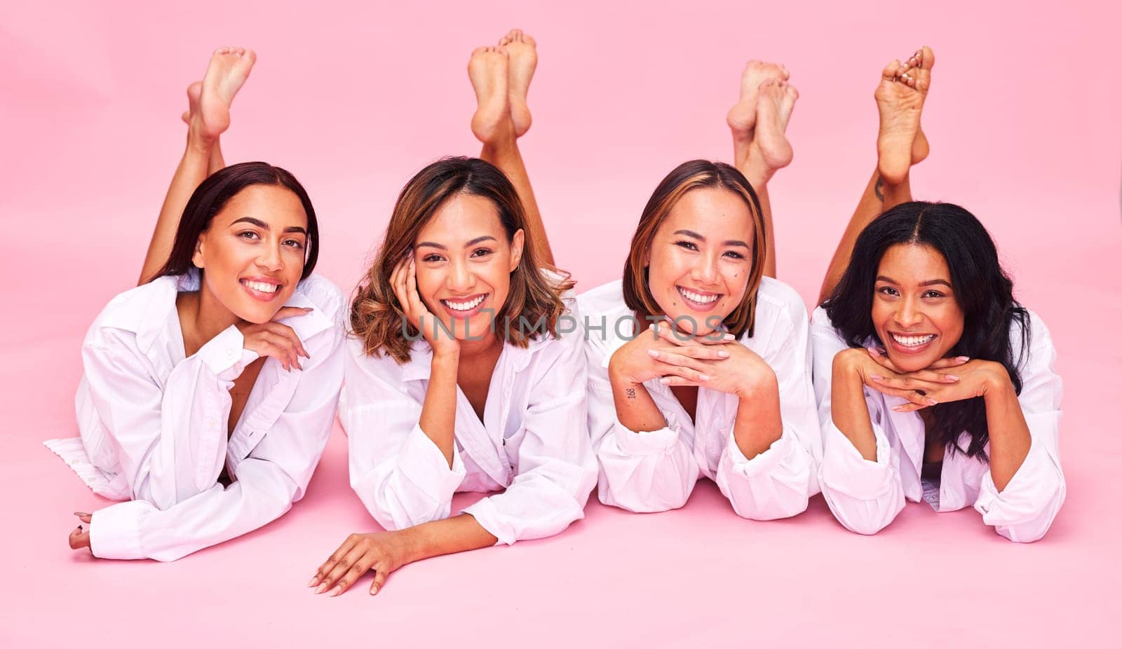 Portrait, smile and lingerie with model friends on a pink background in studio for natural skincare. Diversity, beauty and wellness with a group of women posing for health, inclusion or cosmetics.
