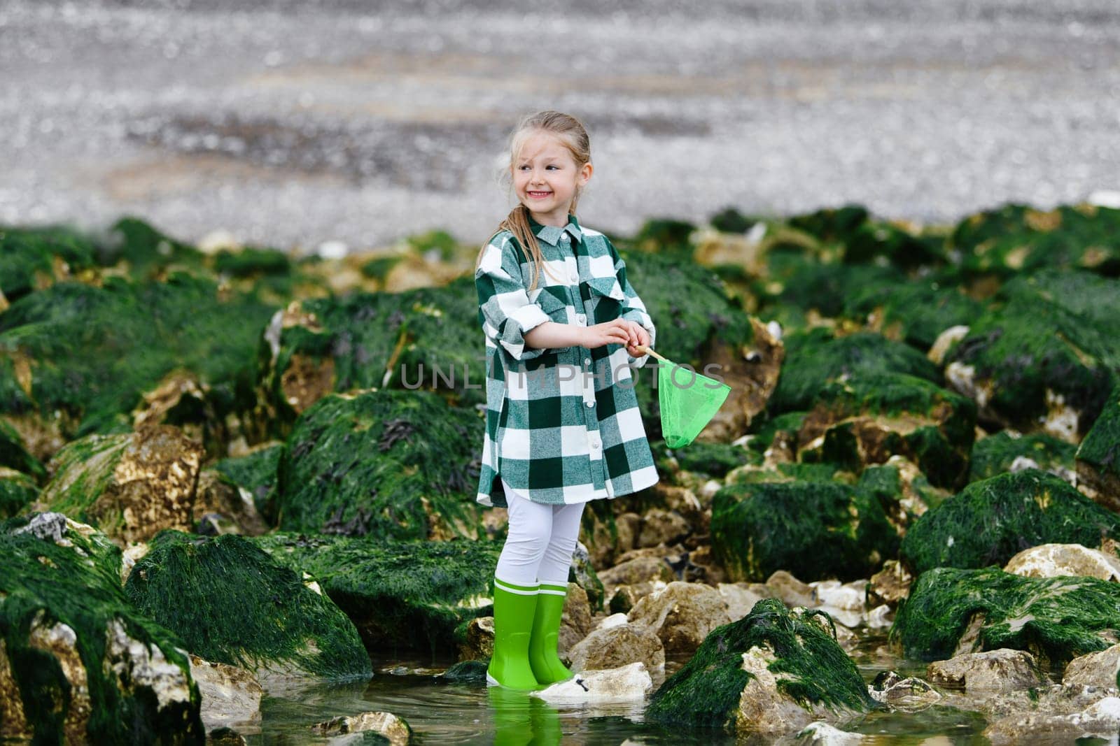 Girl in rubber boots catches crabs