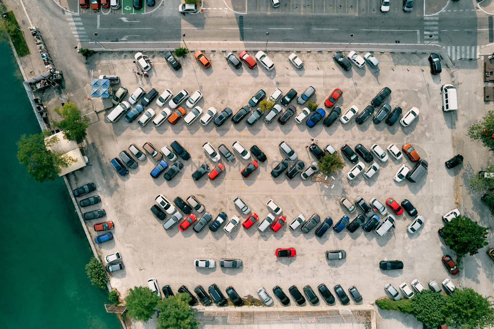Large parking lot with colorful cars standing in rows on the seashore. Drone. High quality photo