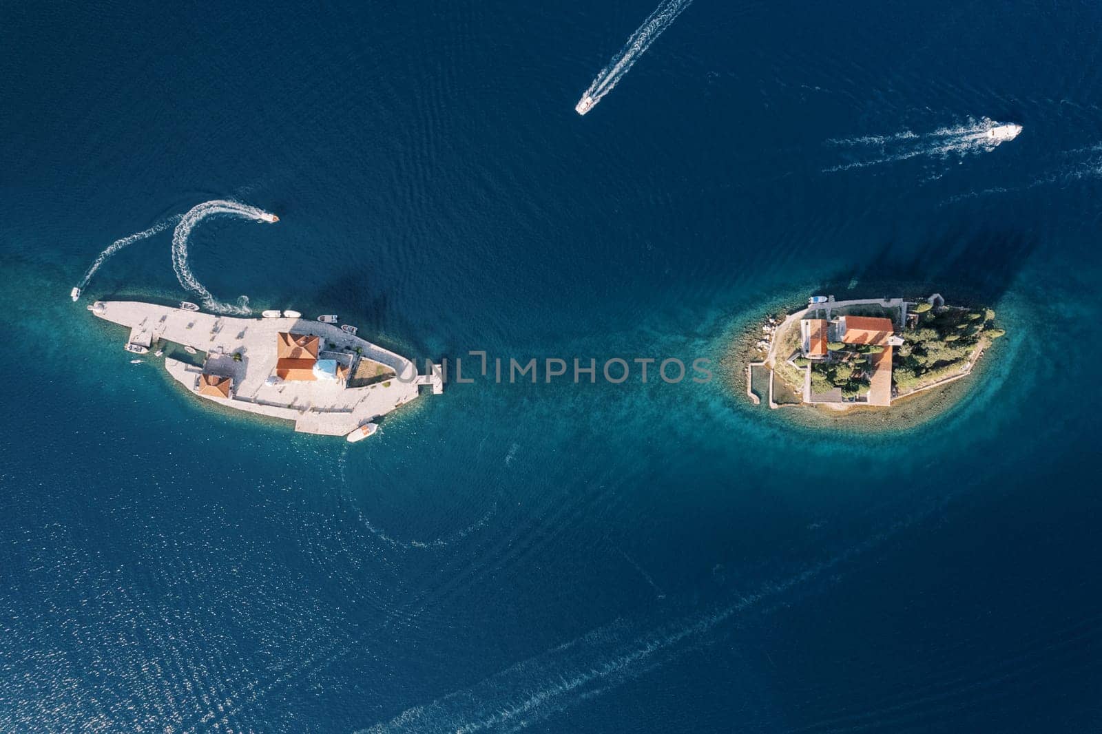 Boats sail around the islands of Gospa od Skrpjela and St. George. Montenegro. Drone. High quality photo