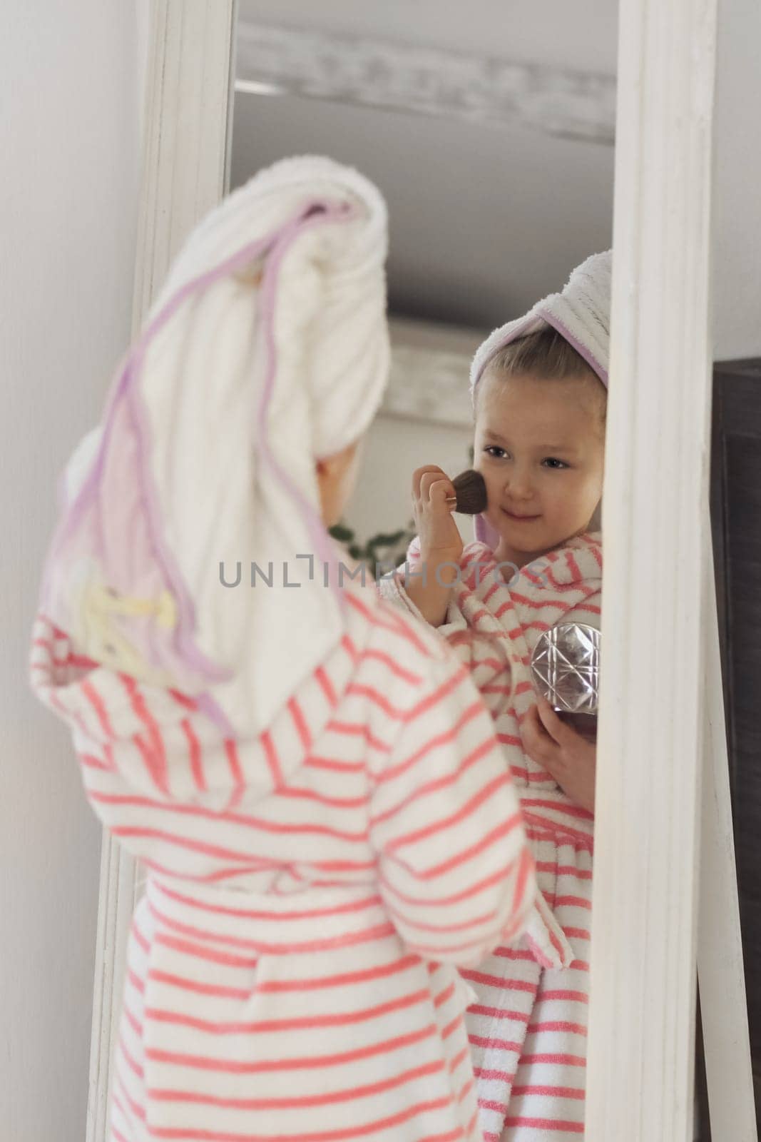 Little girl with a towel on her head doing makeup