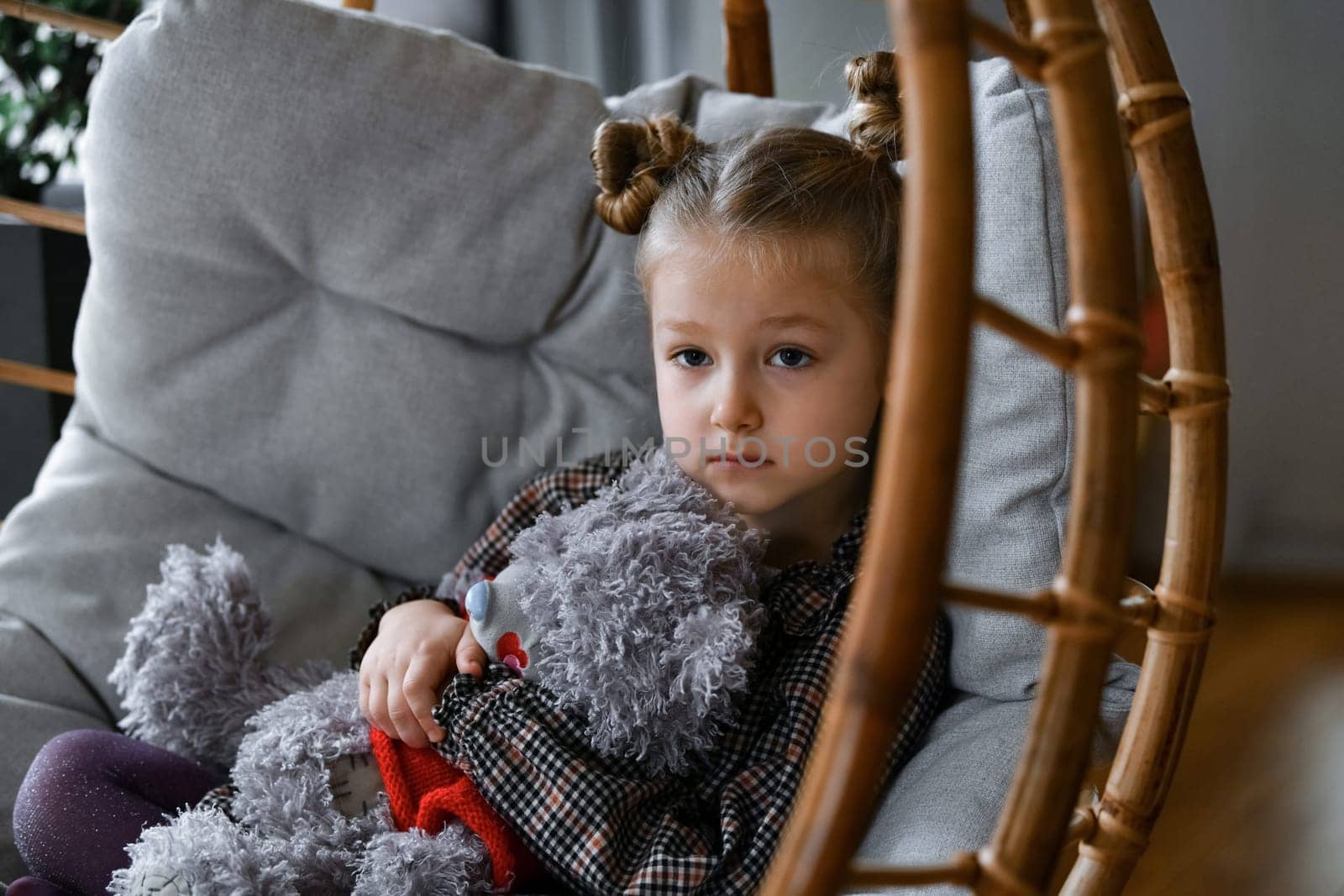 A small girl in a suspended bamboo chair