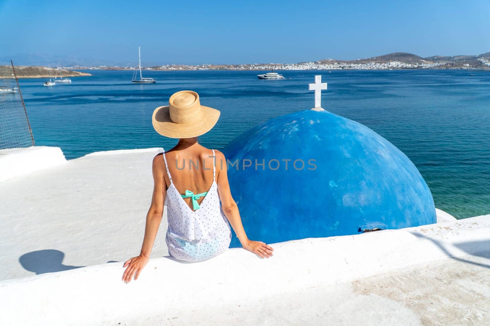 Woman sitting at Monastery of St. John's of Deti in Paros, Greece