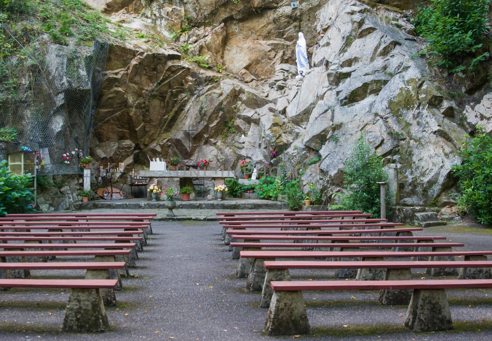 Cave grotto with the benches for prayer under open-air