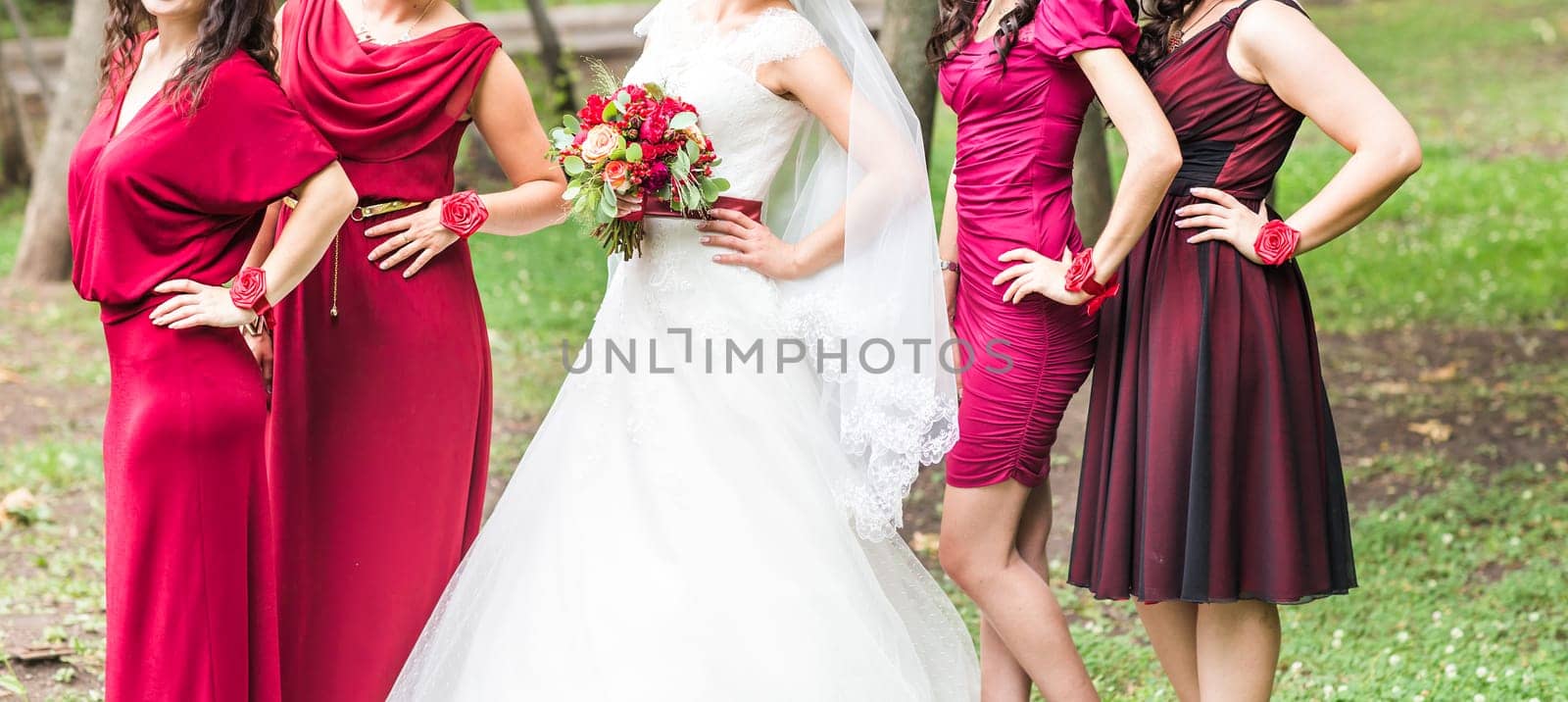 Bride with bridesmaids on the park on the wedding day.