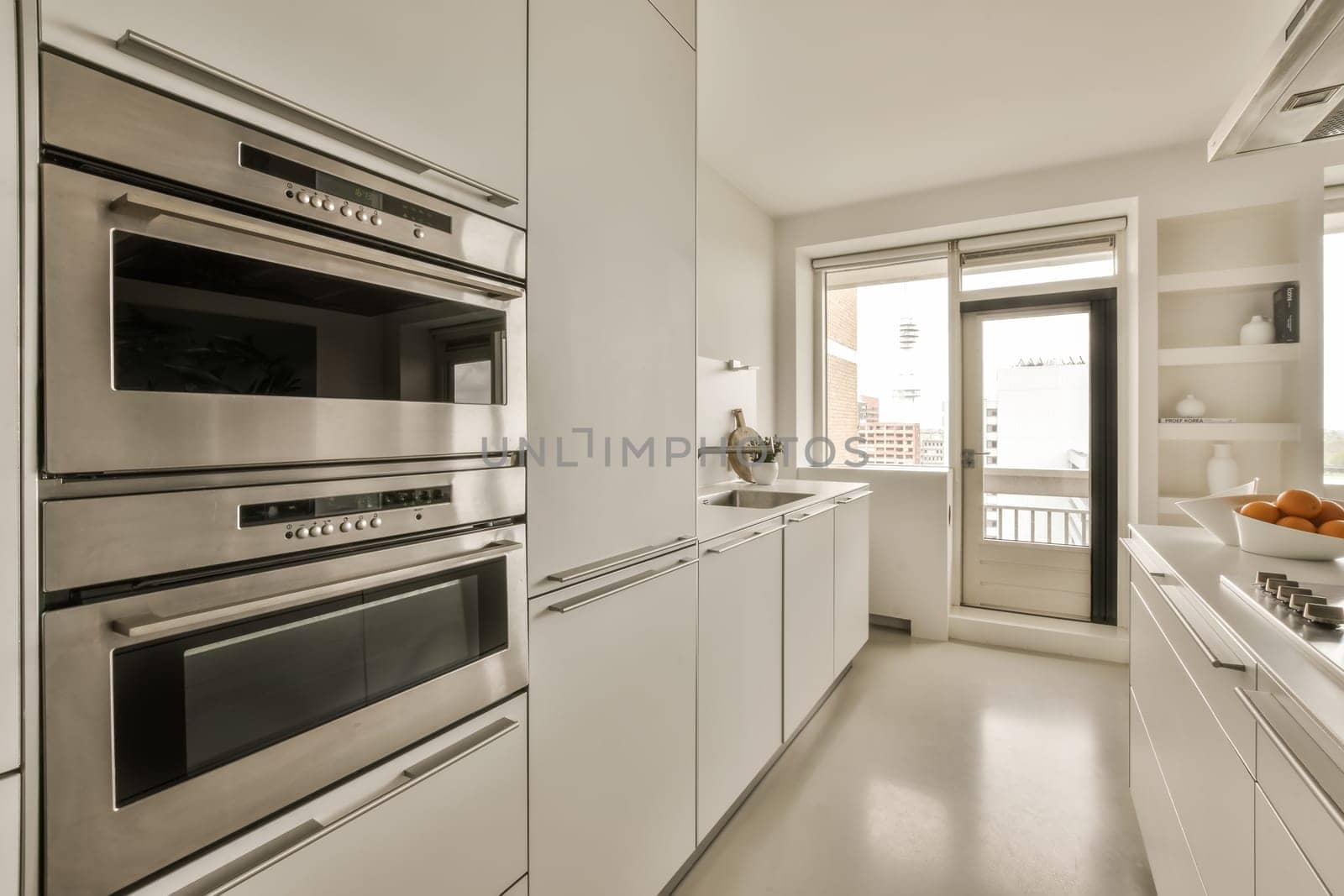 a kitchen with stainless steel appliances and white cabinets by casamedia