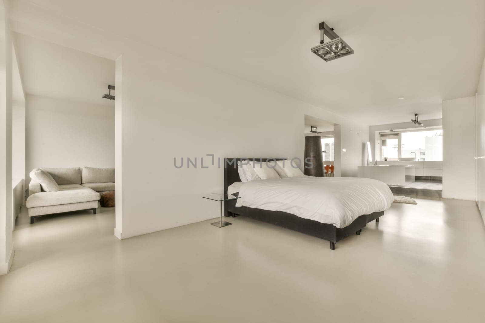 a modern bedroom with white walls and light gray flooring the room is well lit, but there is no one in sight