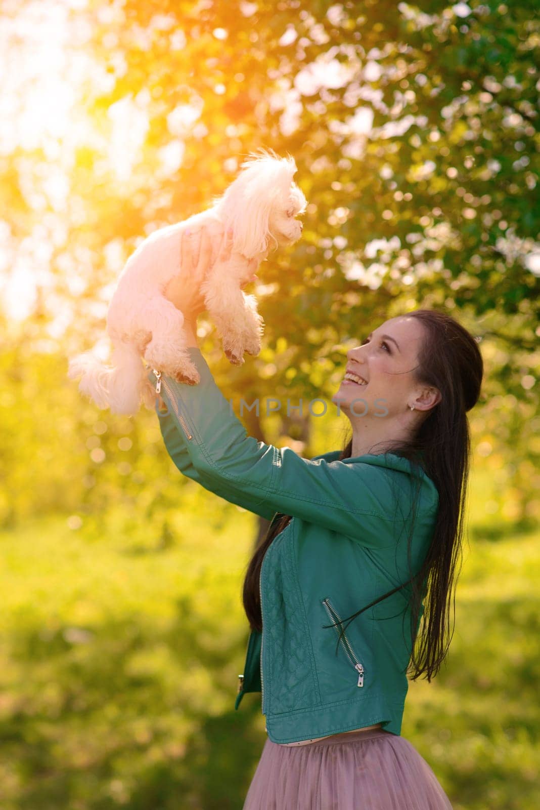 Young girl with her dog. Puppy white dog is running with it's owner. Conception about friendship, animal and freedom.